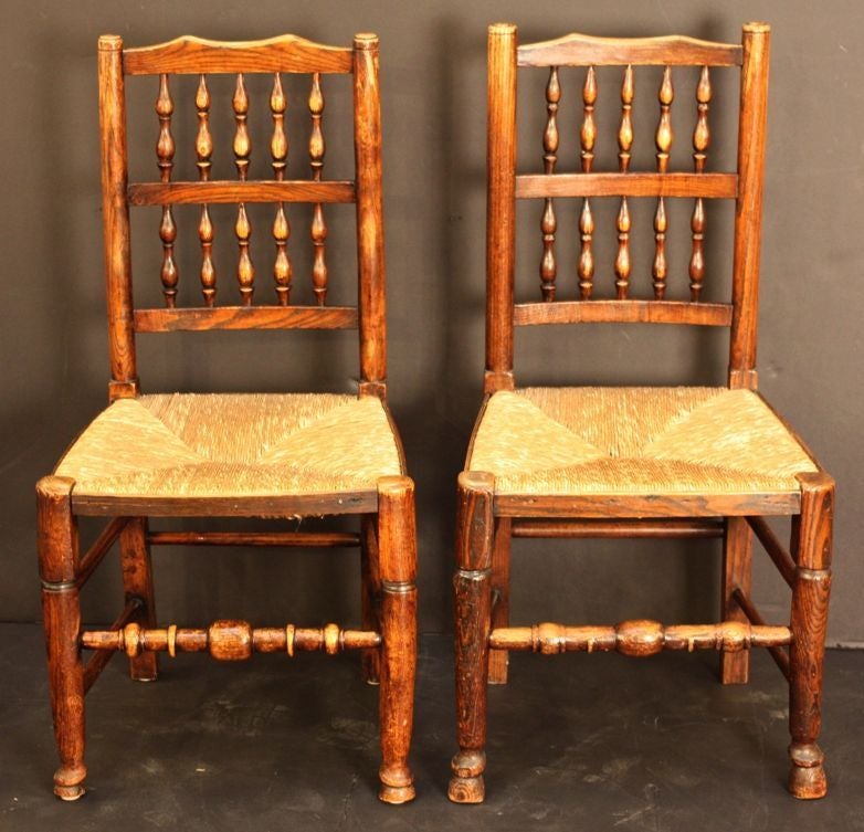 A fine set of four English spindle-back chairs with handsome woven rush seats.
Featuring nicely-turned spindles on the backs and fine-turned legs and supports, slight variation from chair to chair.

A Classic English country or farm or cottage