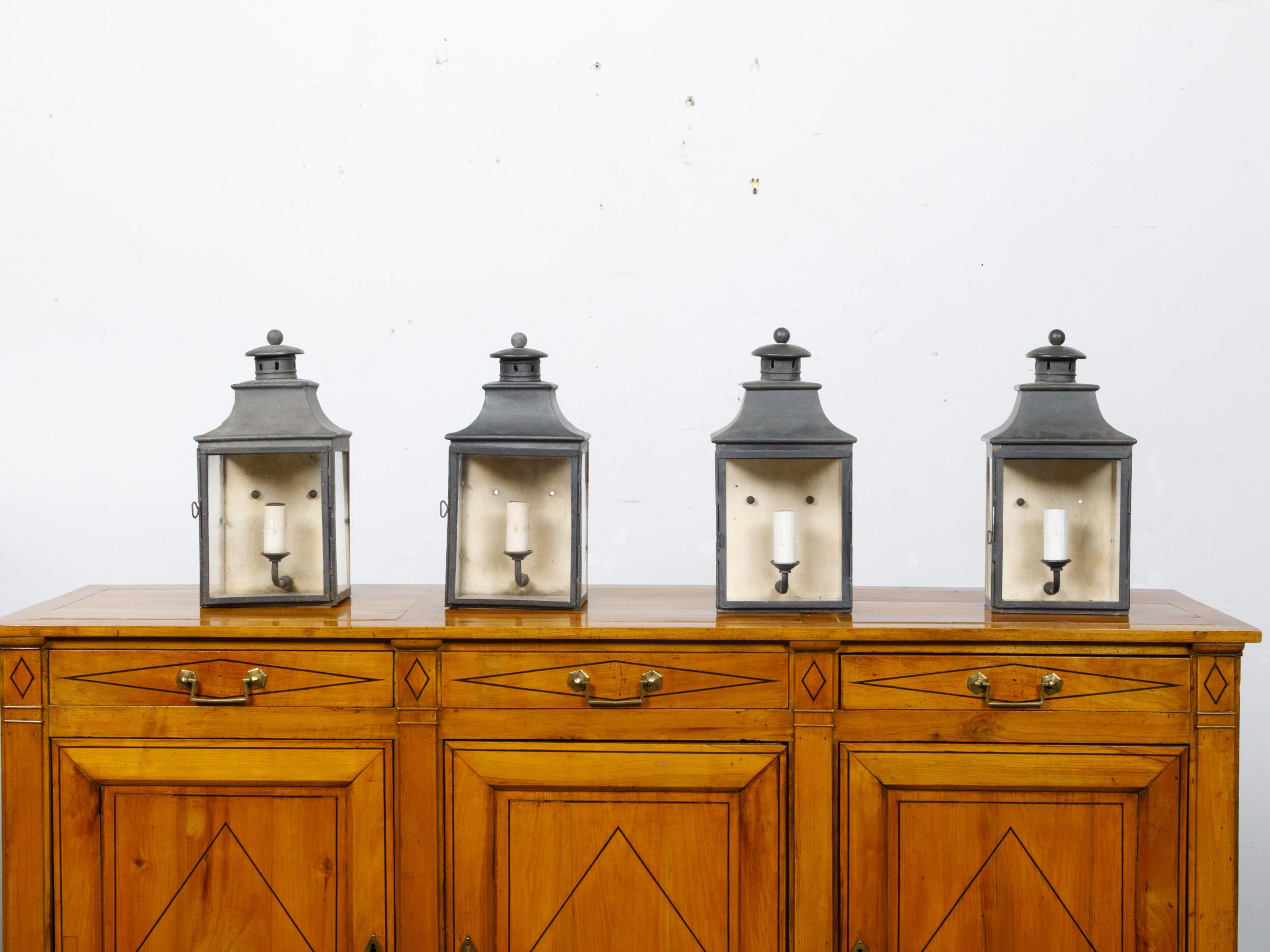A set of four English Turn of the Century copper wall lanterns from circa 1900 with glass panels and single lights. This set of four English copper wall lanterns, dating back to the turn of the century circa 1900, exudes a timeless charm and a hint