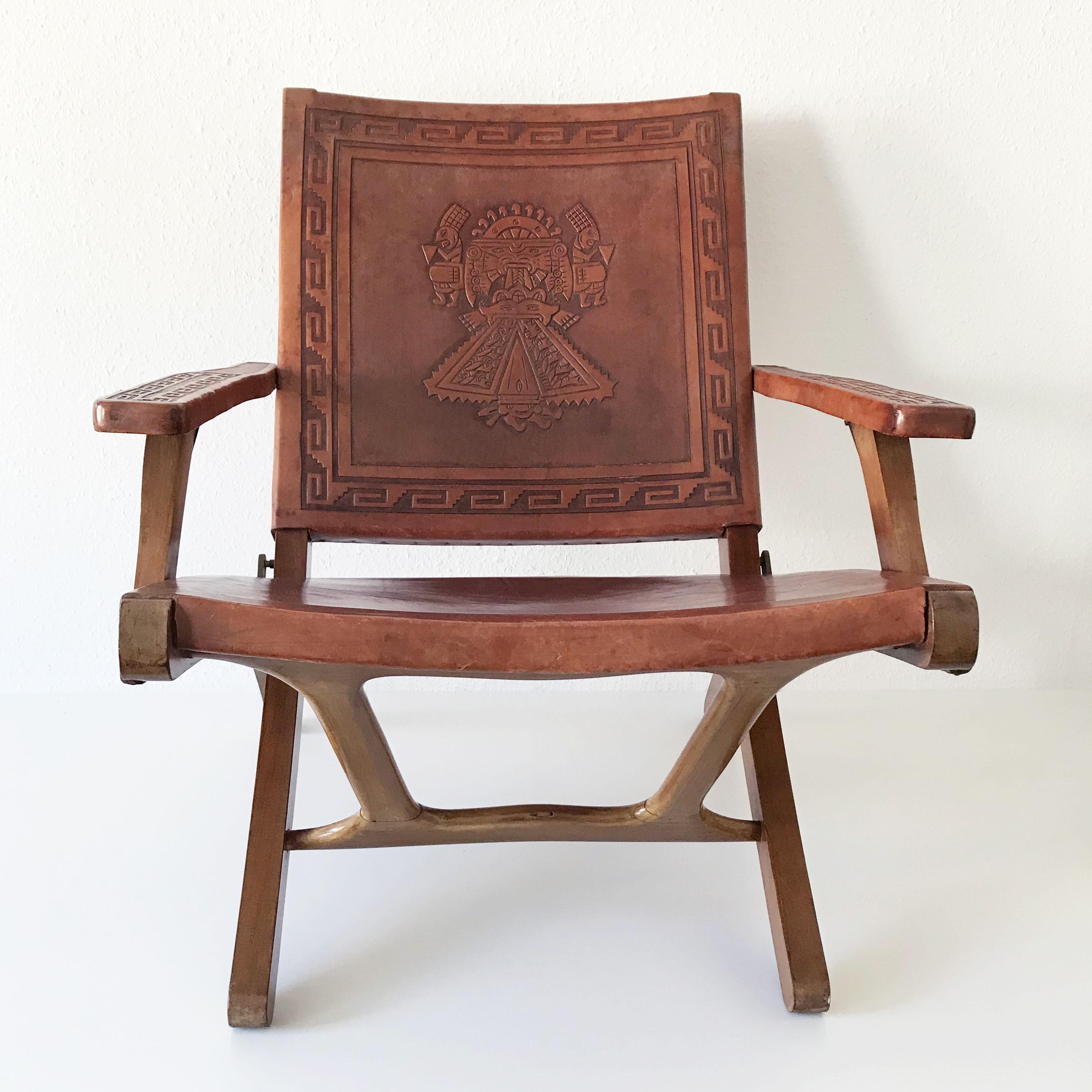 Extremely rare set of four Mid-Century Modern folding arm chairs. Designed by Angel I. Pazmino in 1960s for Muebles de Estilo, Ecuator. The chairs are executed in wood and thick cognac colored saddle leather embossed with different Inca patterns.