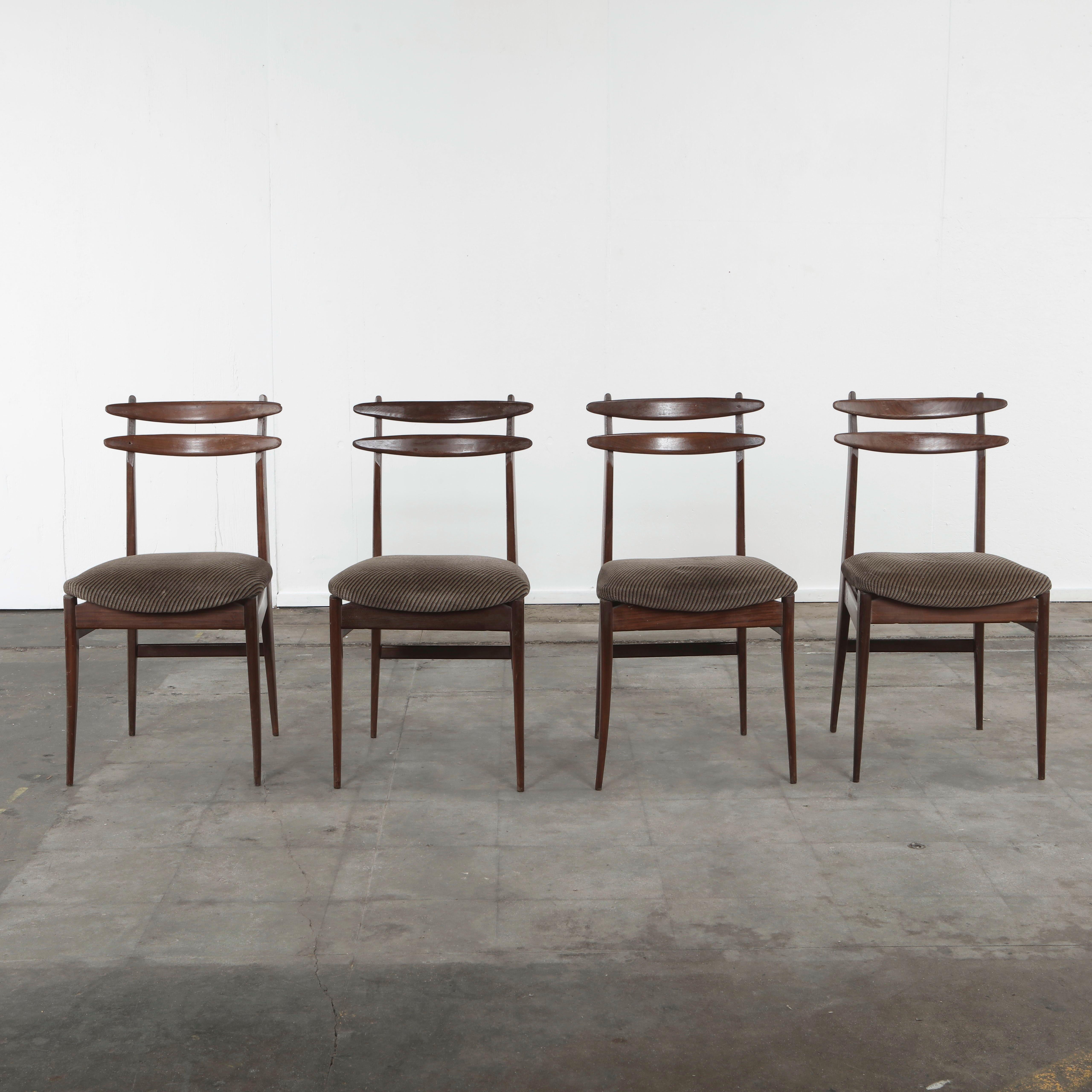 Refined set of four Italian mid-century dining chairs from the 1950s, crafted in solid walnut with elegant, sculptural lines. The design features a gently curved double-slat backrest, tapered legs, and a finely balanced silhouette that exemplifies