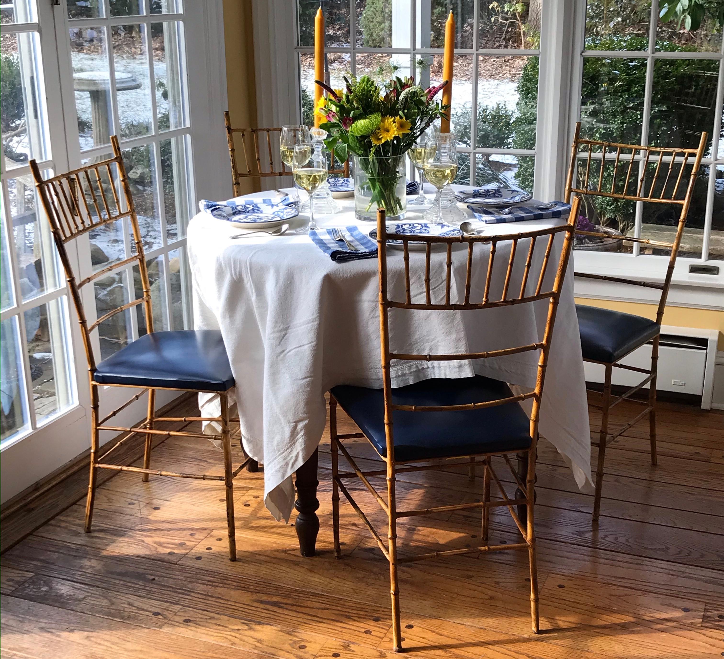 Set of four faux bamboo iron chairs. Four vintage Continental painted faux bamboo on modeled iron side chairs with original blue leatherette seats; perfect for the breakfast room in Palm Beach or card room in the Hamptons. Europe, circa