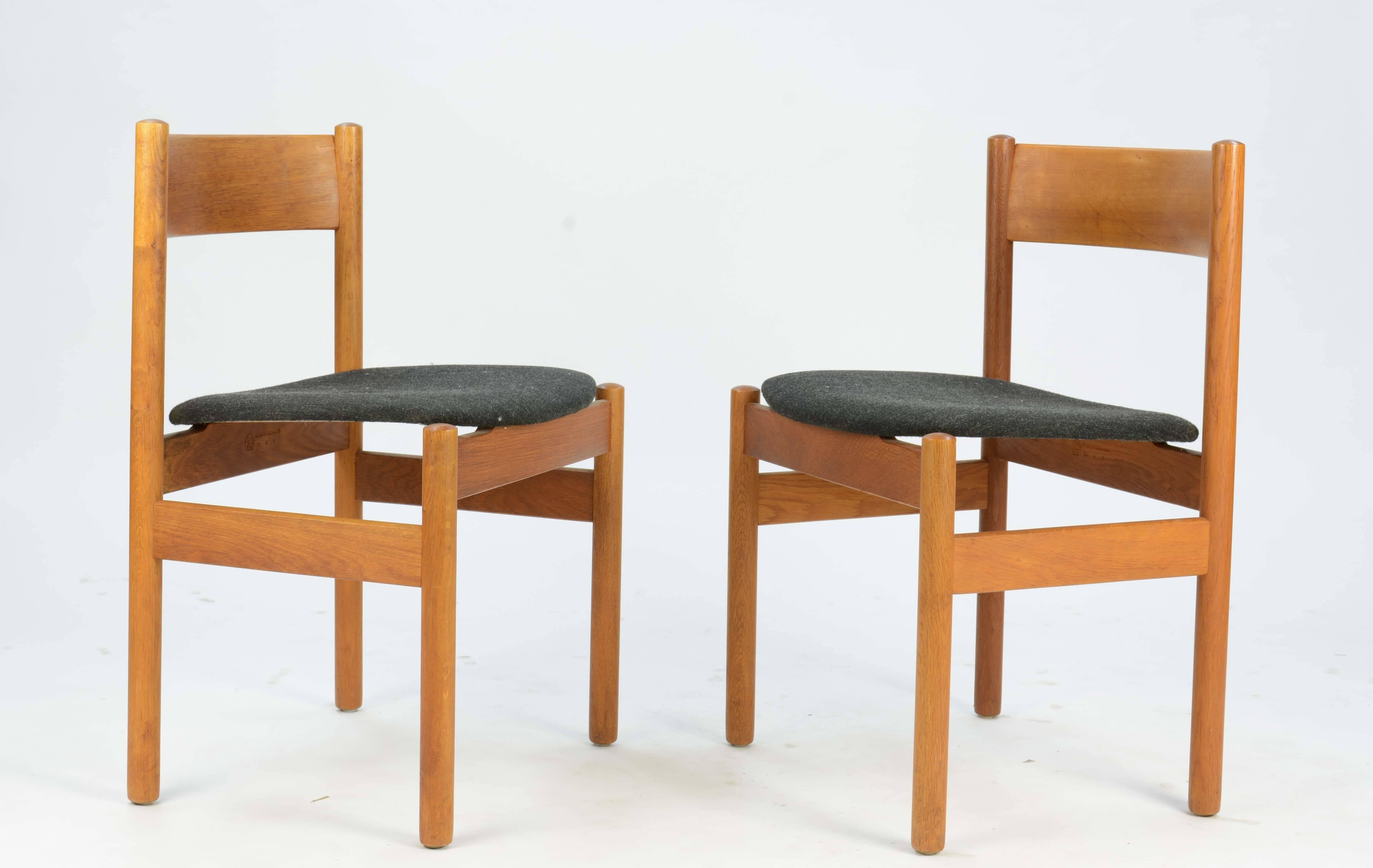 A set of four FDB Mobler of Denmark dining chairs that appear to have floating seat and sculpted contoured back in teak and oak. The chairs are labelled with the early FDB brand.