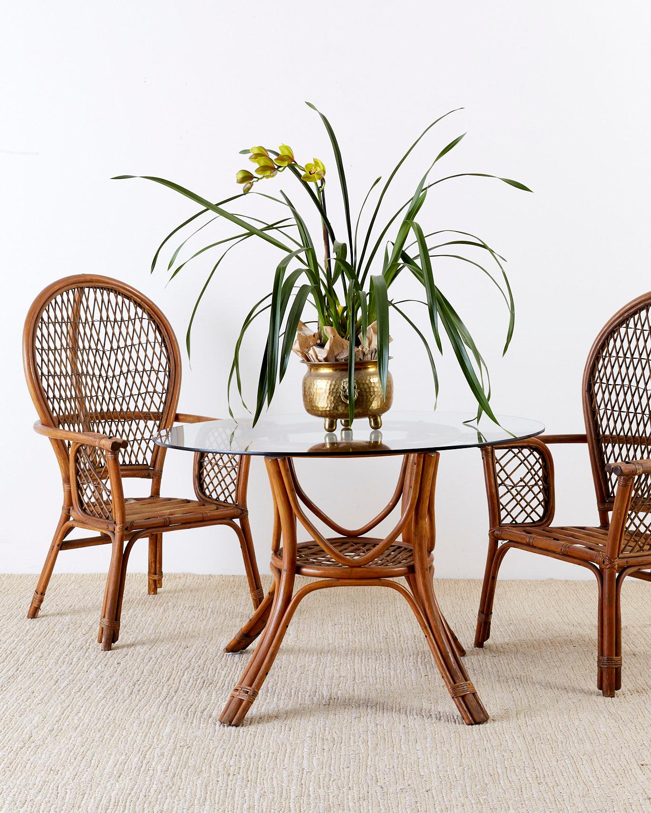 Midcentury set of four rattan bamboo peacock lounge chairs featuring a balloon back with an open lattice fretwork design. Attributed to Ficks Reed and constructed from rattan and wicker. The original finish is faded with a lovely vintage patina. The