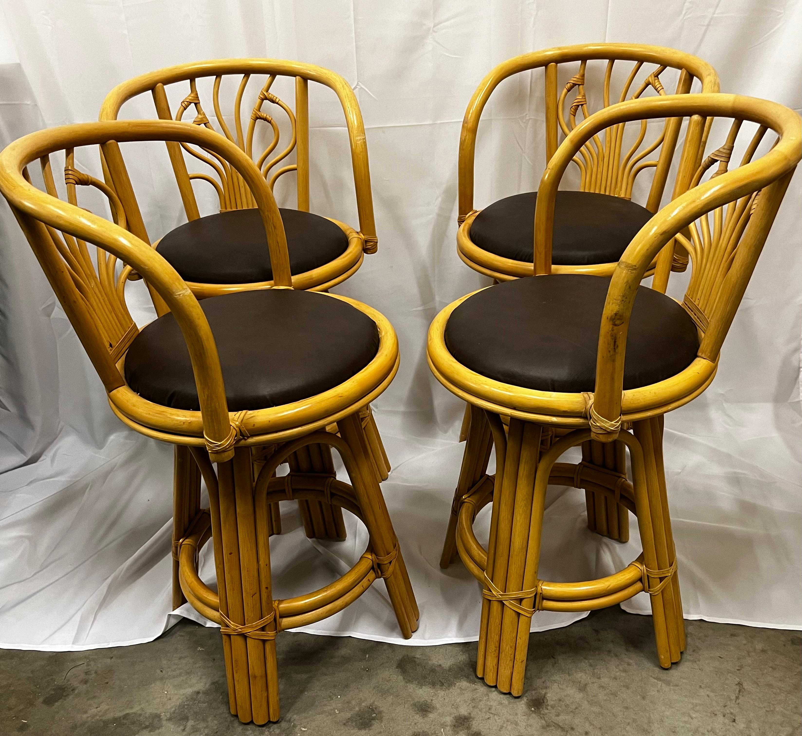 Set of four ficks Reed Style Swivel Rattan bar stools laced with bamboo strips.
The round seats are upholstered in a brown fabric and are in perfect condition.
The general condition of the bar stools is excellent.