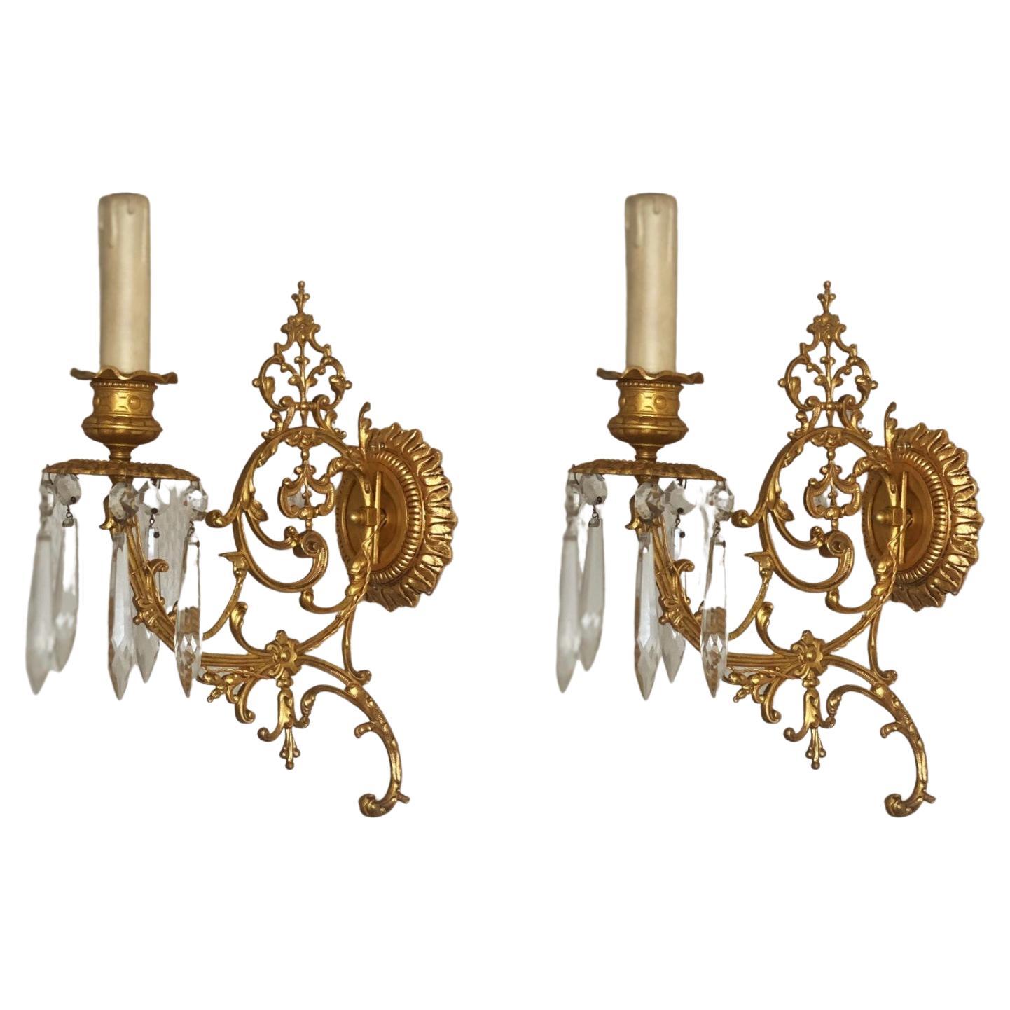 An extremely elegant and high quality set of four Louis XVI period doré bronze (fire-gilded bronze) wall candle holders, wonderfully elaborate in fine and precise detail, decorated with long crystal icicle prisms, France, late 18th century. Now