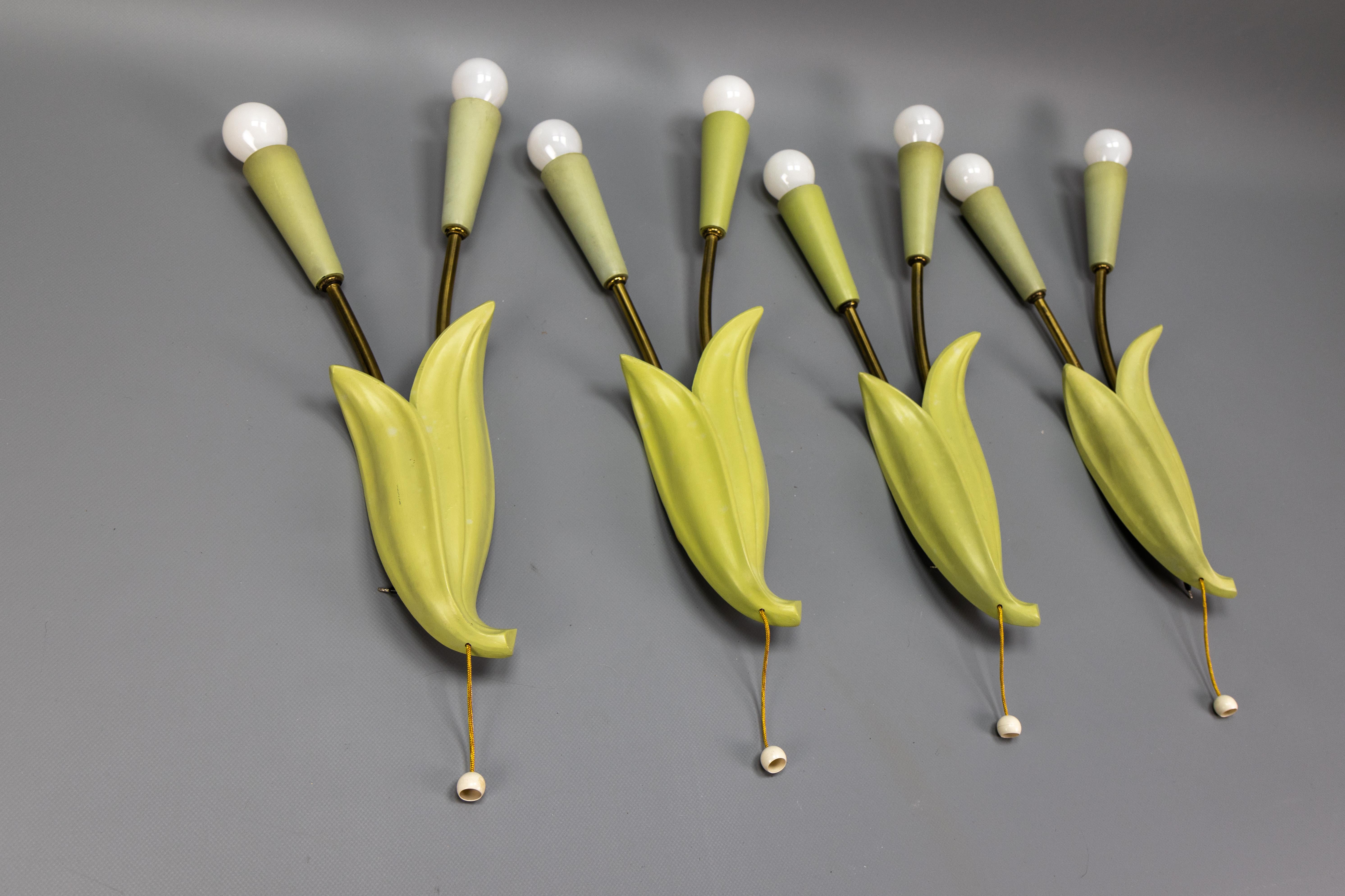 Appliques à deux lumières en forme de fleurs vertes pastel de Ott-Leuchten, ensemble de quatre, Allemagne, vers les années 1950.
Il s'agit d'un ensemble impressionnant et magnifique de quatre appliques murales vintage, chacune avec deux lumières,