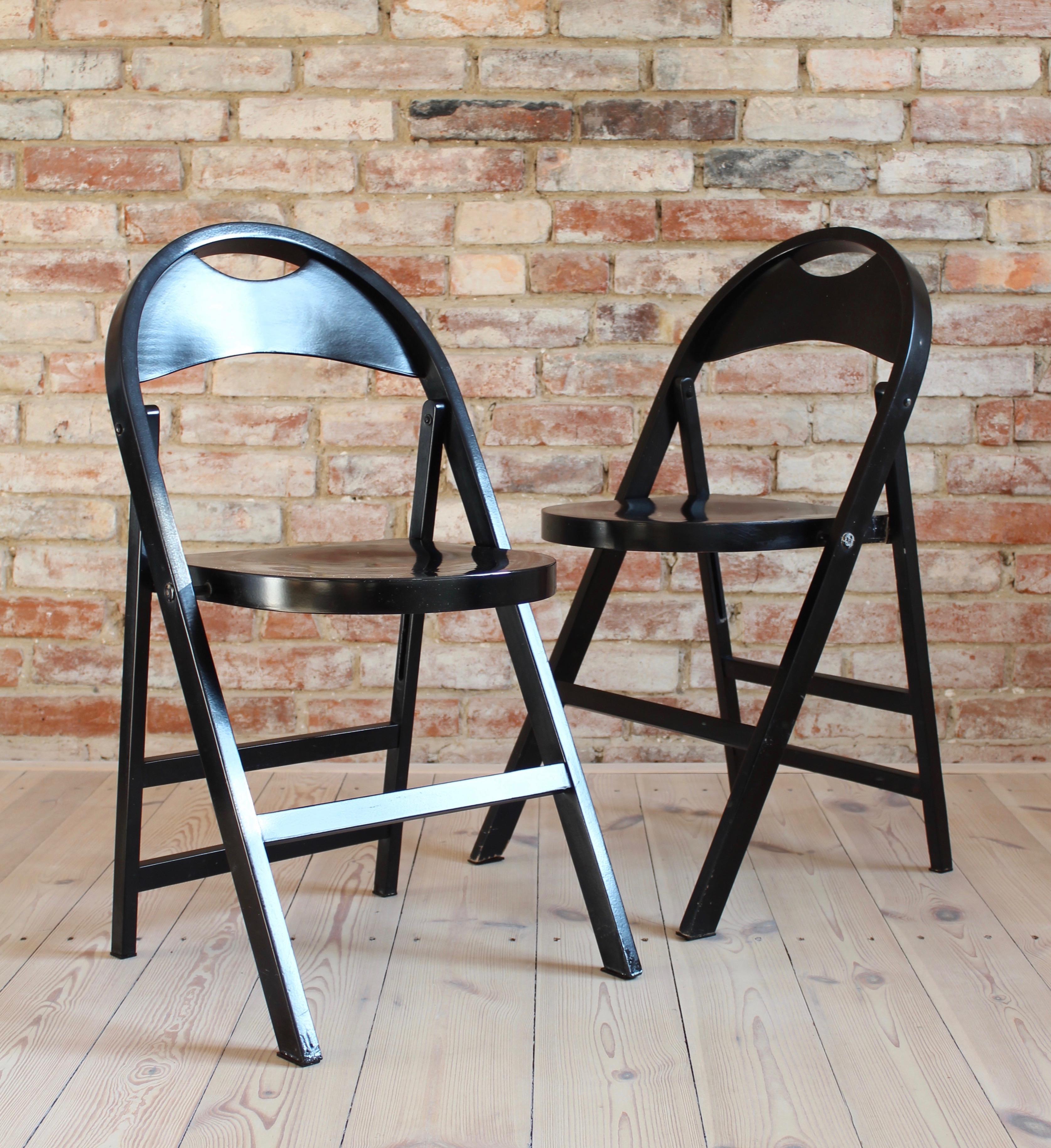 This set of four folding chairs is a famous model B 751 by Thonet. The design is very classical and the folding is a very practical feature. The chairs have a deep black color with a subtle shine. There are little distressed spots shown in the