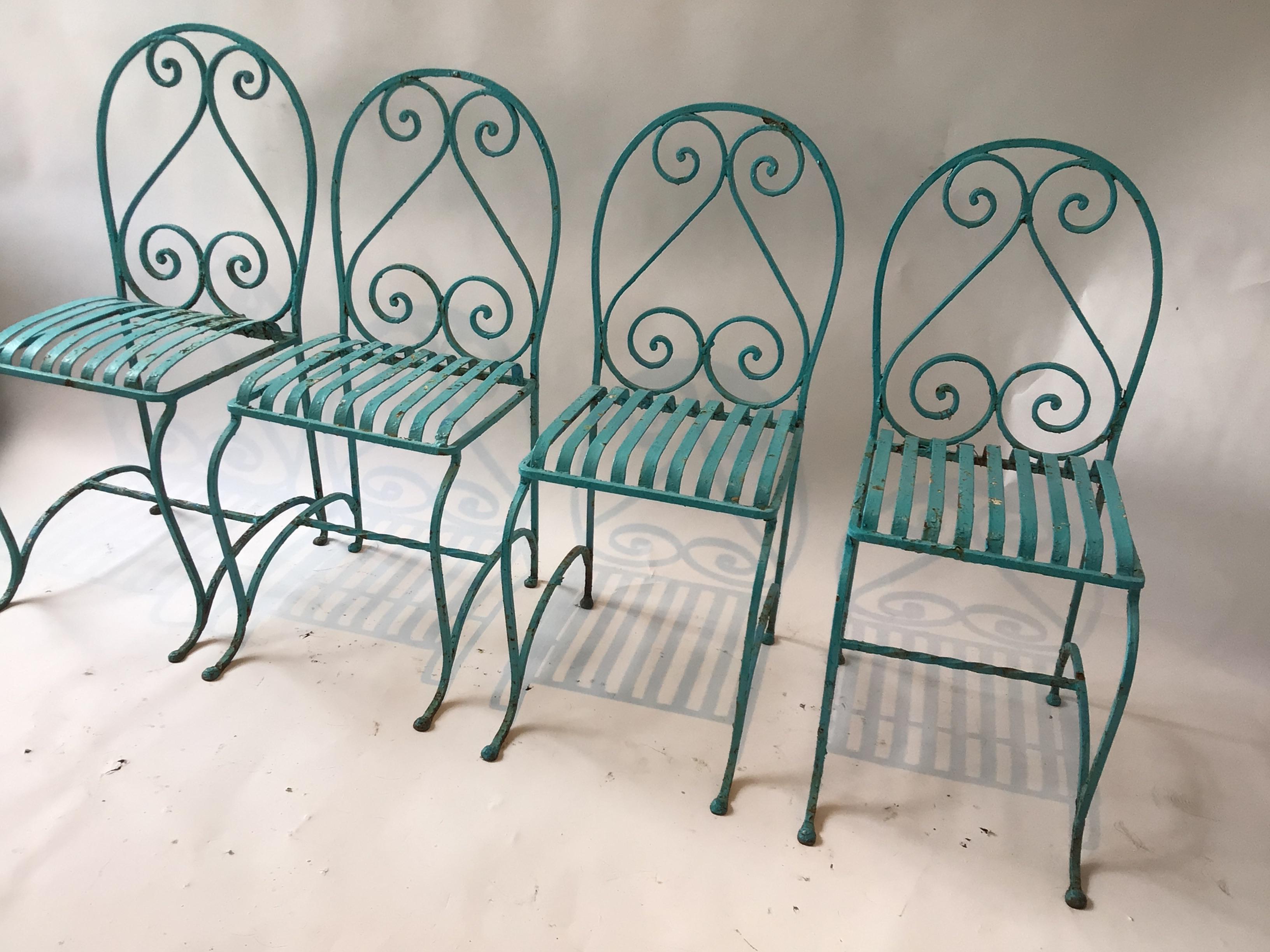 Set of 4 French 1930s Iron garden chairs with spring seats. One chair is missing the lower cross bar.