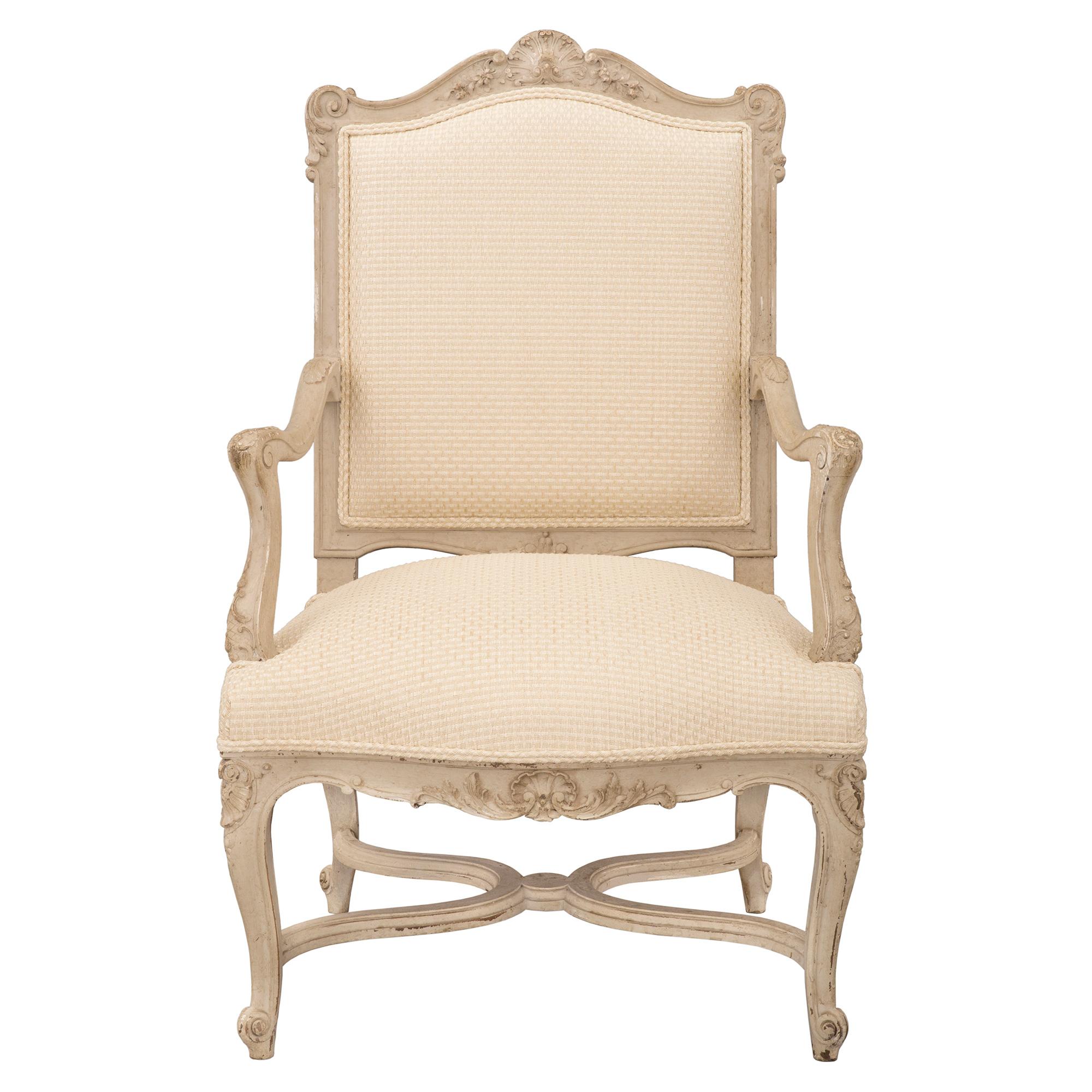 Un ensemble élégant et très décoratif de quatre fauteuils français du 19ème siècle, de style Louis XV, patinés. Chaque chaise est surélevée par de jolis pieds cabriole avec de fines volutes attachées par de belles civières en forme de X avec des