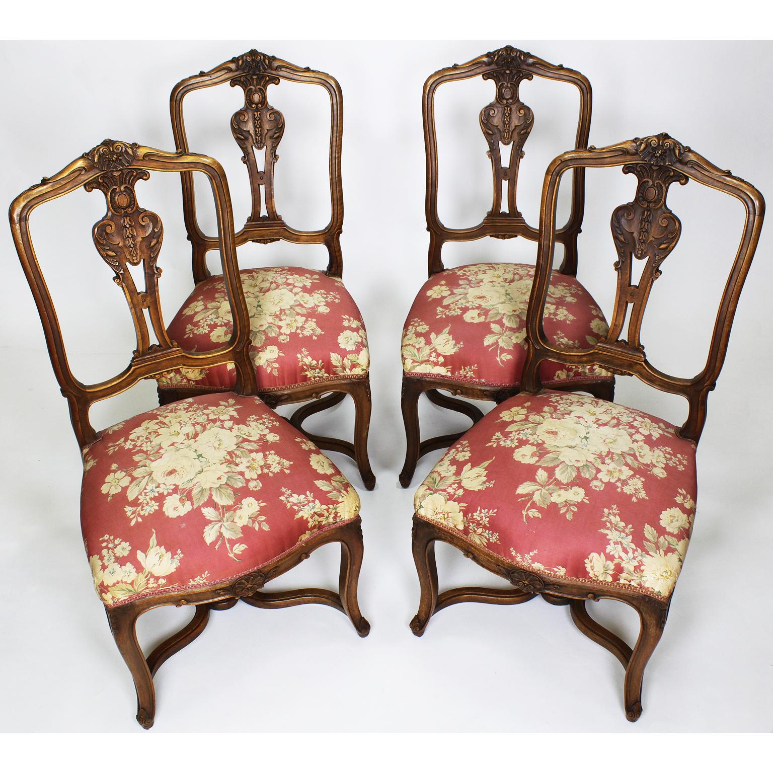 A fine set of Four French, 19th century Louis XV style carved walnut parlor side chairs. The intricately carved backrests with an arched back and raised on four cabriolet legs conjoined with an 