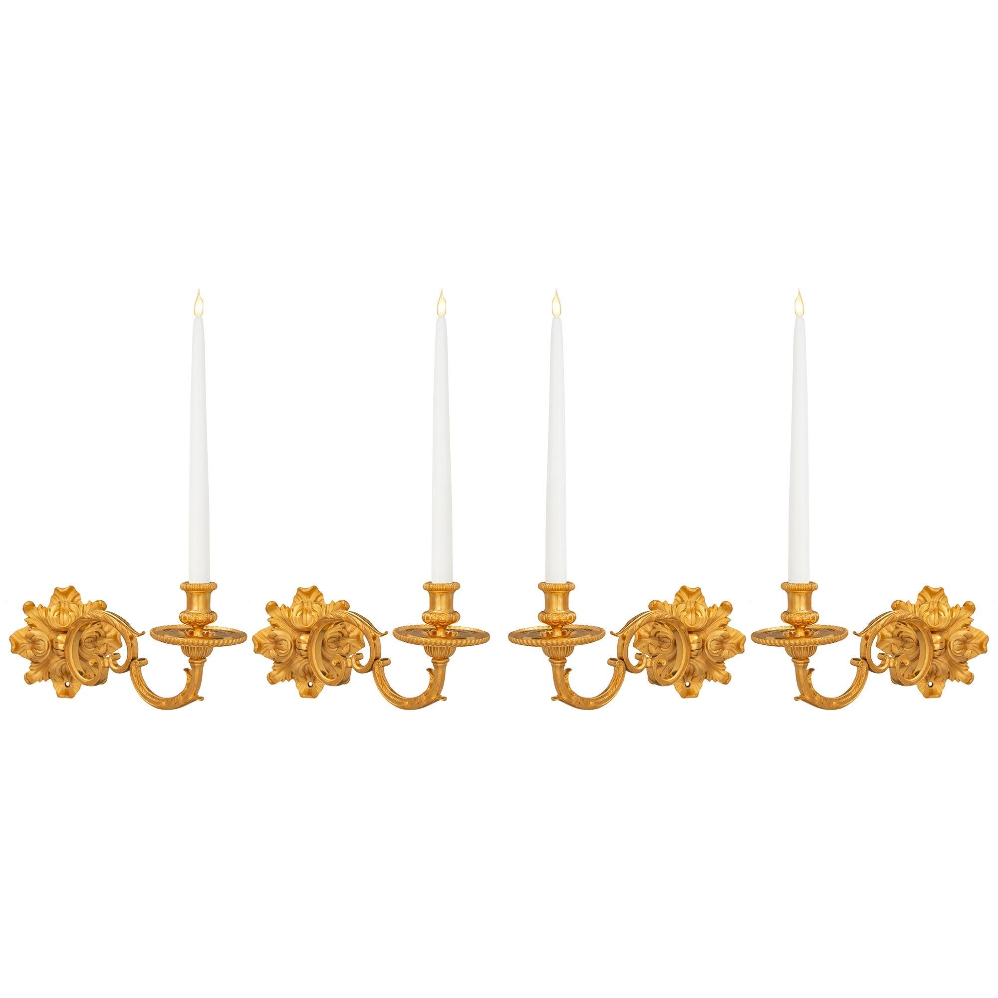 A beautiful set of four French 19th century Louis XVI st. ormolu sconces. Each one arm is centered by a wonderfully richly chased backplate with acanthus leaf designs in a superb satin and burnished finish. The elegantly scrolled arm is adorned with