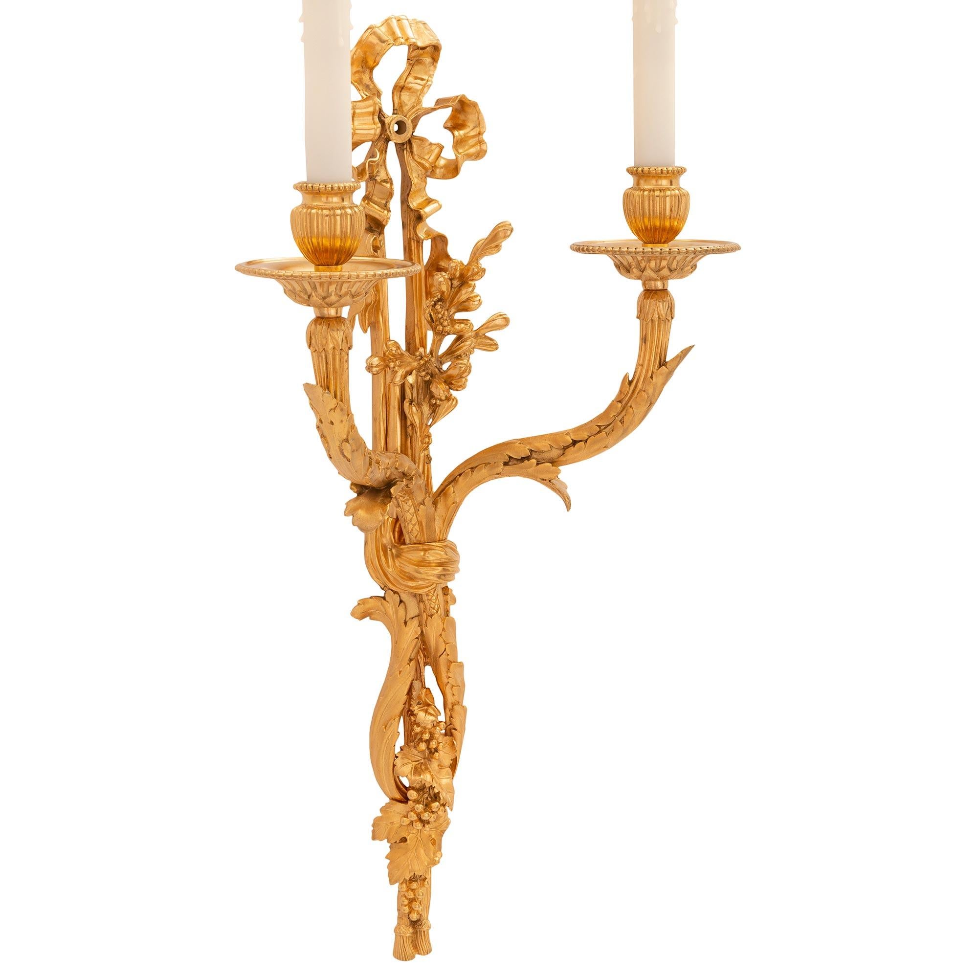 An extremely high quality and rare set of four French 19th century Louis XVI st. Ormolu sconces. Each two arm sconce displays sensationally chased grapes and vines below the scrolled reeded arms, decorated with large overlapping acanthus leaves.