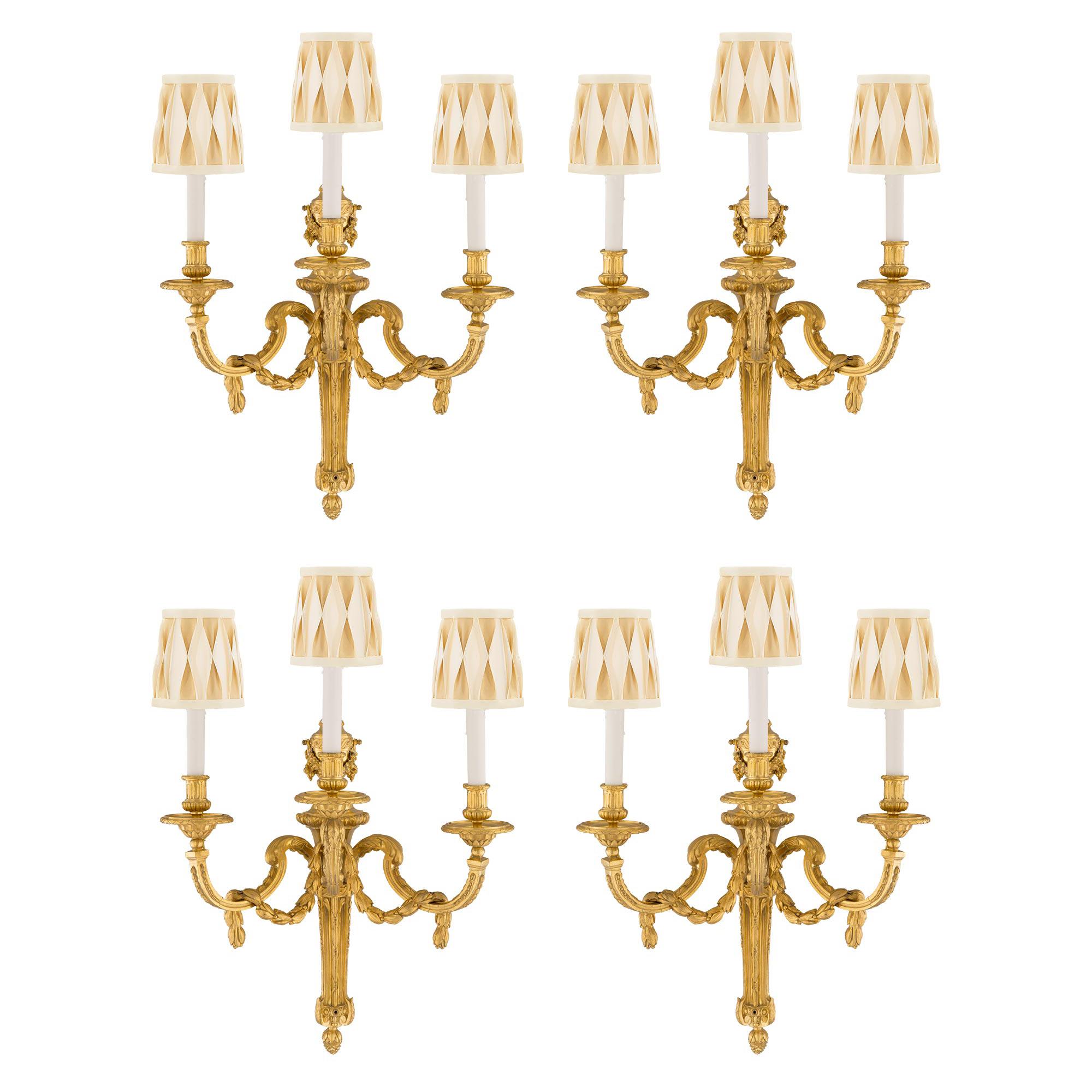 Ensemble de quatre appliques en bronze doré à trois lumières de style Louis XVI du XIXe siècle français en vente