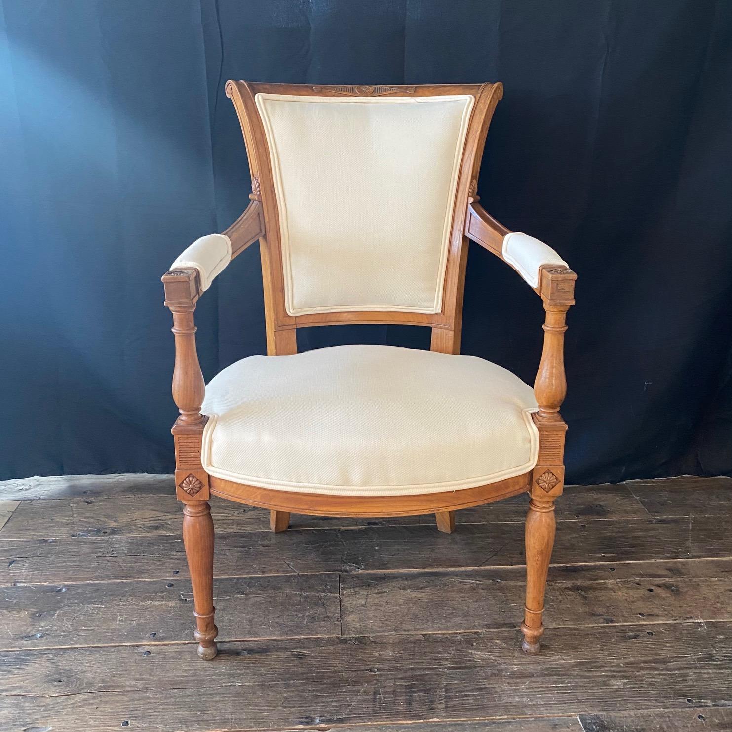 A fine 19th century set of 4 French neoclassical dining chairs from the Directoire period with stunning intricately carved walnut frames (see photos for detail). Lovely curved backsplats and reupholstered in neutral high end fabric designed to show