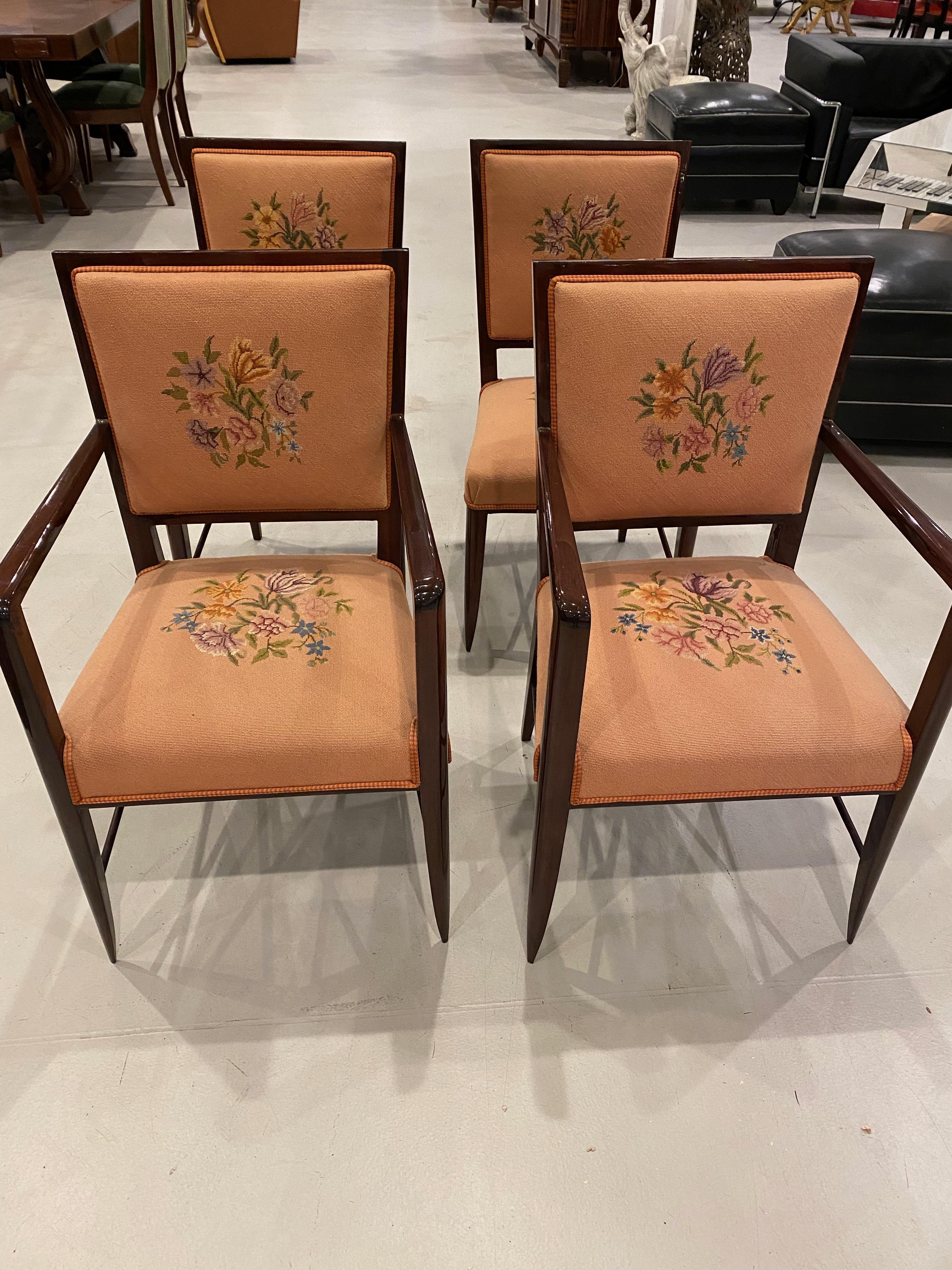 Stunning set of four French Art Deco chairs. Two of the chairs having arm rest while the other two are armless. Upholstered with floral design on the seat back and the seat. The wood frames have bee fully restored. All four chairs are ready to be