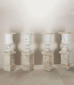 Set of Four French Cast Iron Urns on Stone Plinths