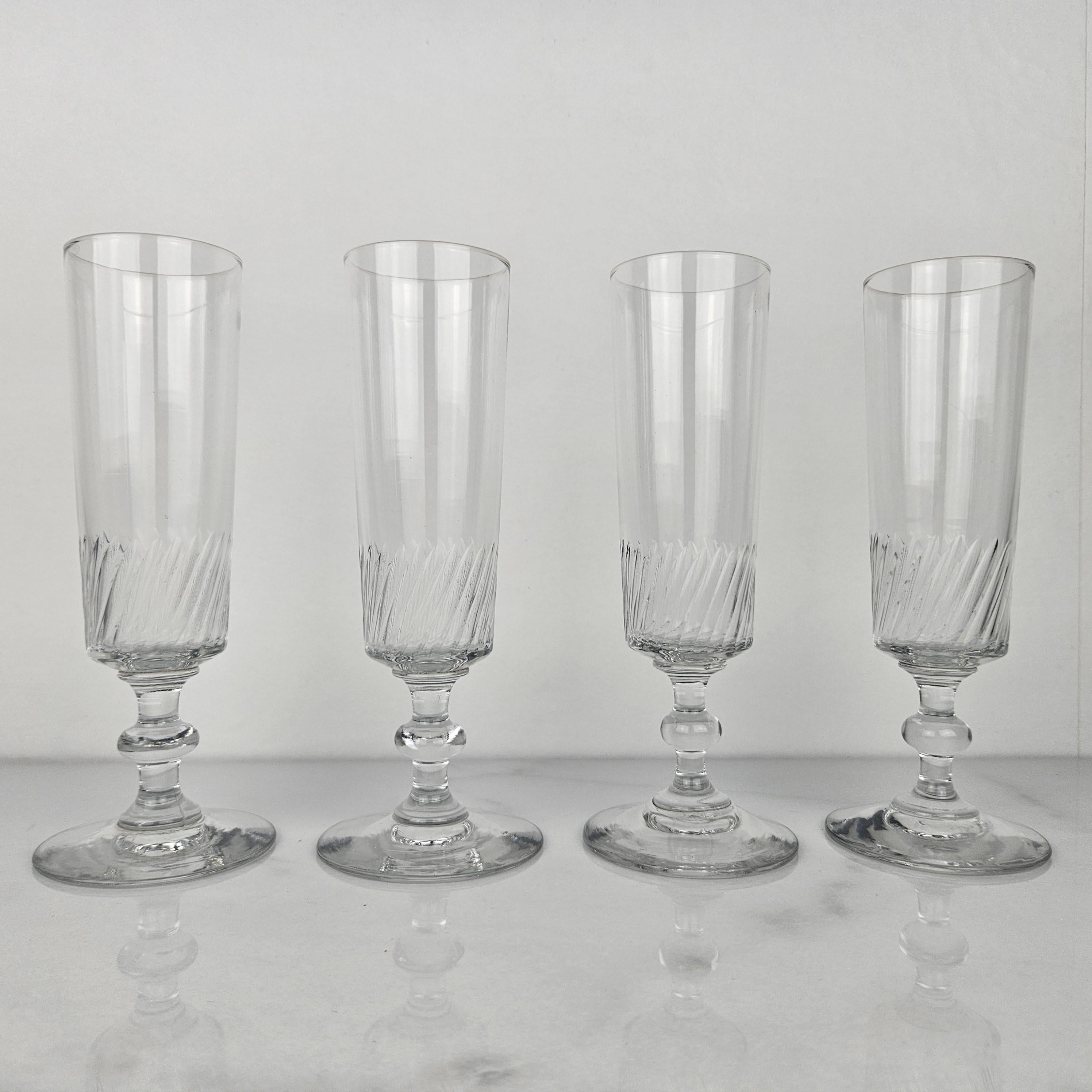 Un bel ensemble de quatre flûtes à champagne françaises en verre, fabriquées à la main vers 1890.  

Ces verres anciens sont soufflés à la bouche. 

Remarquez les très beaux détails et le design élégant.
Méticuleusement fabriquées à la main, ces