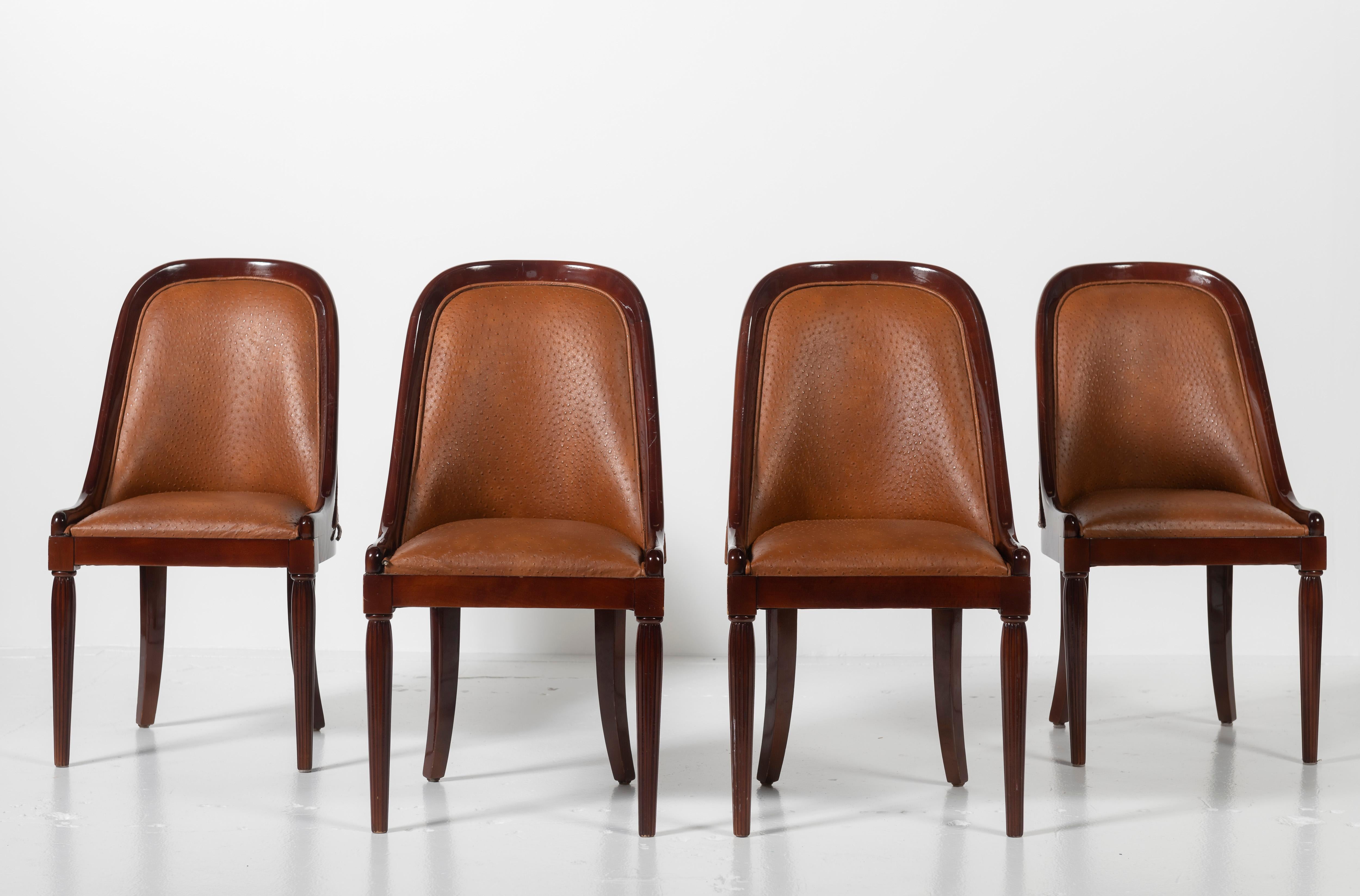 Set of four French Art Deco dining chairs in mahogany with ostrich leather upholstery and trim. These chairs are certain to lend sophistication to your table or as side chairs. The Chairs are in good condition, with some minor scratches to the wood.
