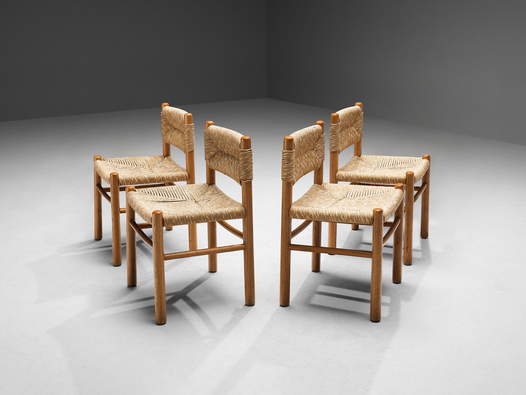 Set of four dining chairs, oak, straw, France, 1960s.

This set of dining chairs features a solid wooden frame, consisting of cylindrical thick legs that are connected to each other with elegant slim horizontal slats. The seats and backrests are