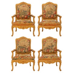 Ensemble de quatre fauteuils français du début du XIXe siècle de style Louis XV en bois doré et tapisserie