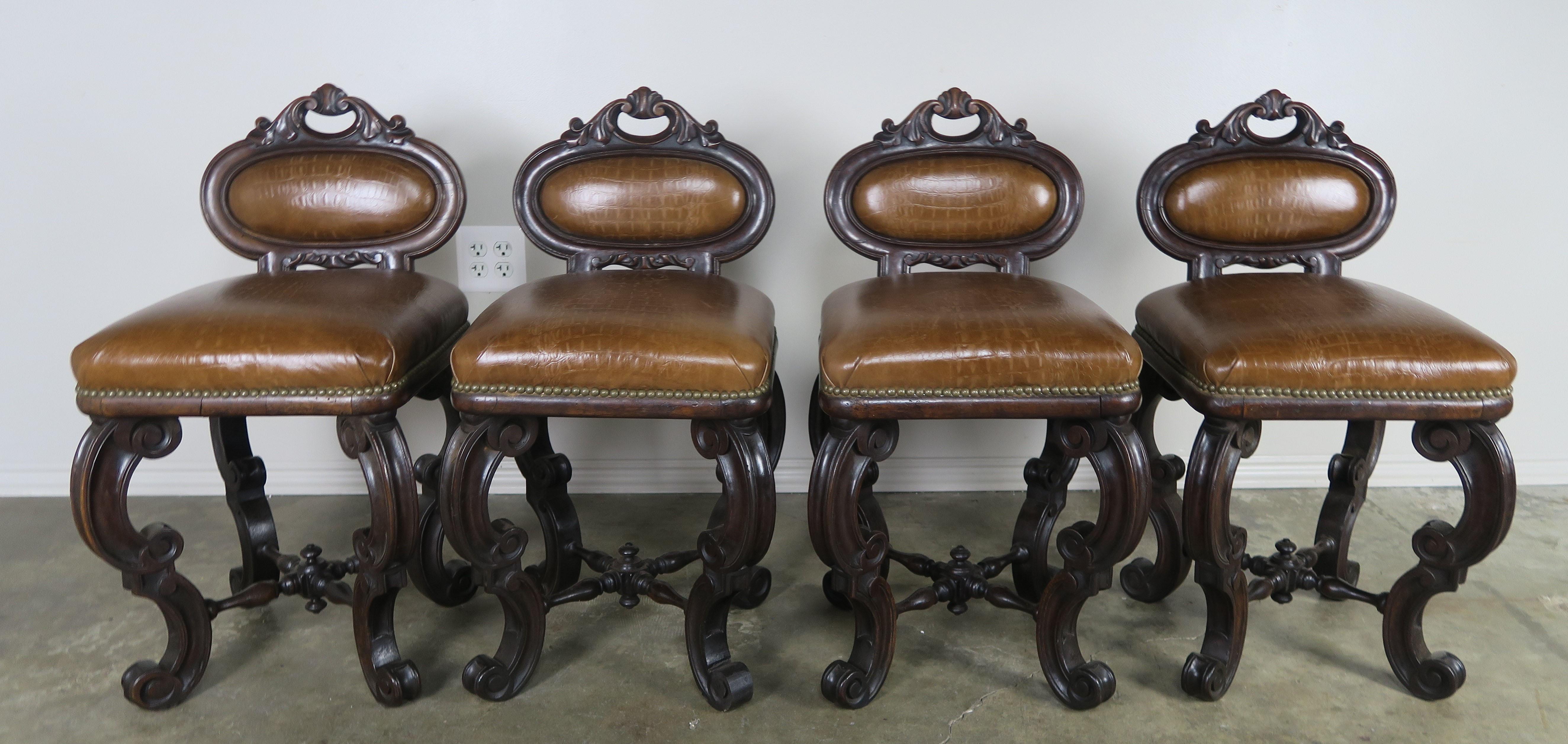 Set of four French embossed leather armchairs upholstered in a leather that resembles crocodile. Great set of petite occasional armchairs that would also make great game chairs around a game table. These unique armchairs stand on four cabriole style