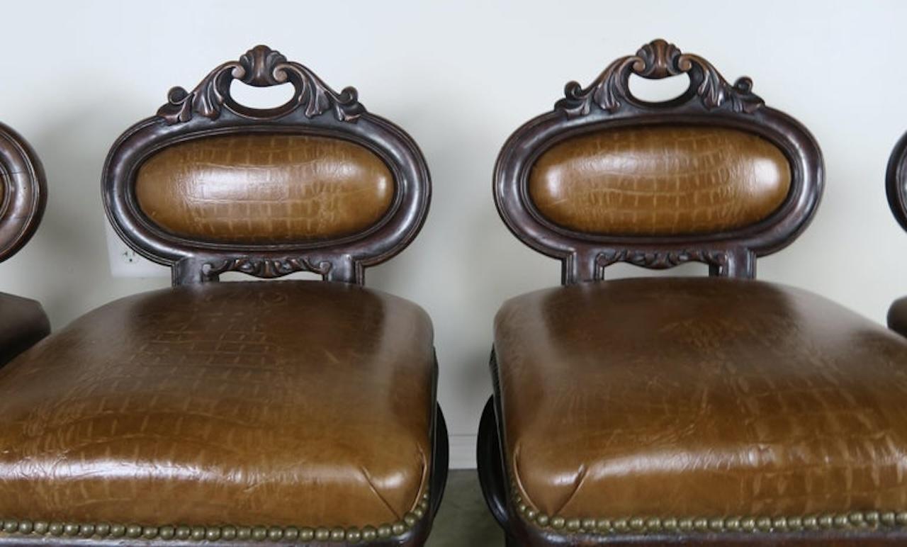 Set of four French embossed leather armchairs upholstered in a leather that resembles crocodile. Great set of petite occasional armchairs that would also make great game chairs around a game table. These unique armchairs stand on four cabriole style