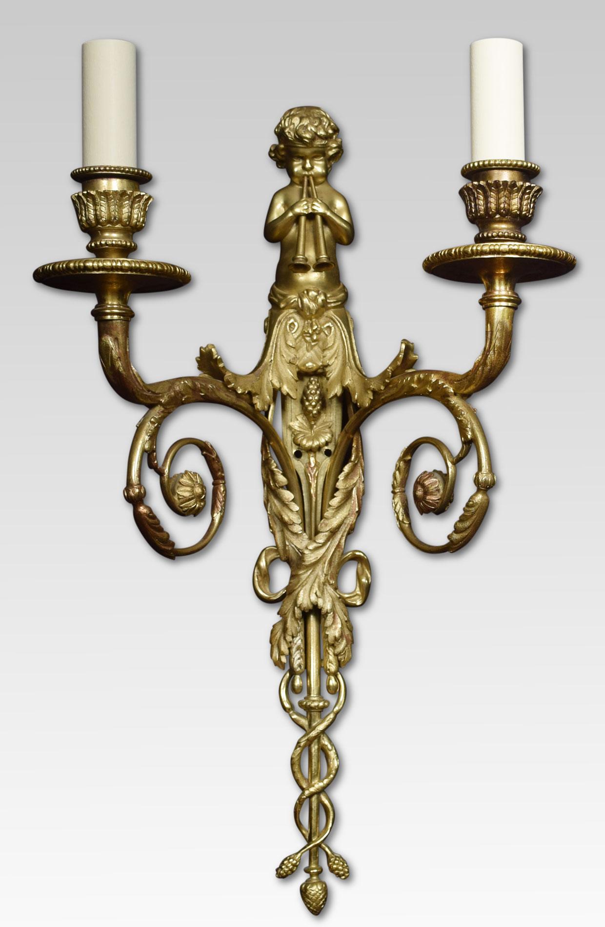 Set of four French gilded bronze wall lights, the leaf scrolling arms having circular drip pans and foliated sconces. Issuing from the backplate surmounted with piping putto and twisting leaf decoration. The wall lights have been converted for