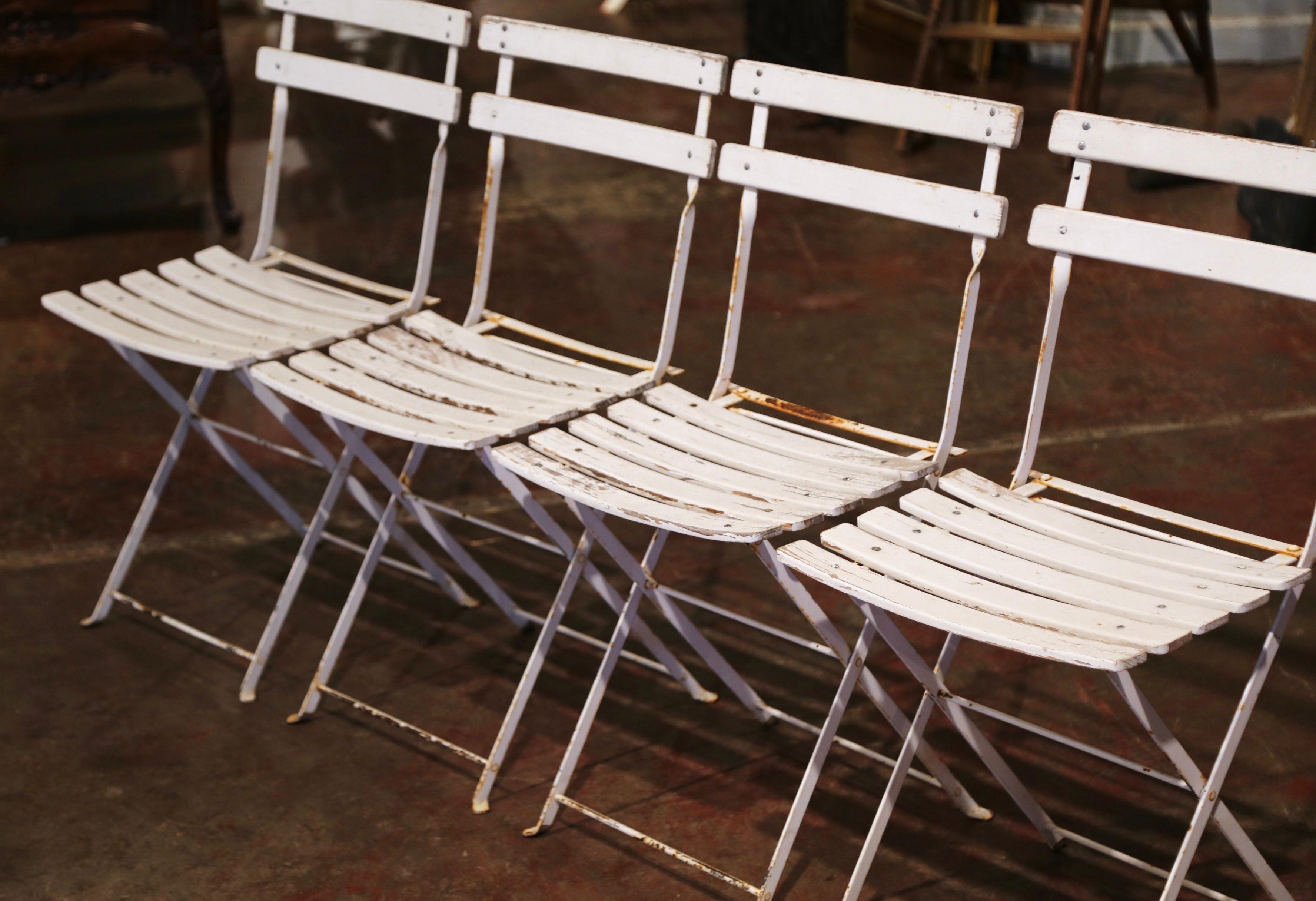 Ces chaises anciennes ont été fabriquées en Normandie, en France, vers 1920. Fabriquée en fer et en pin, chaque chaise est dotée d'un dossier à deux échelles et d'un siège à six lattes, et possède un mécanisme de pliage pour un rangement compact