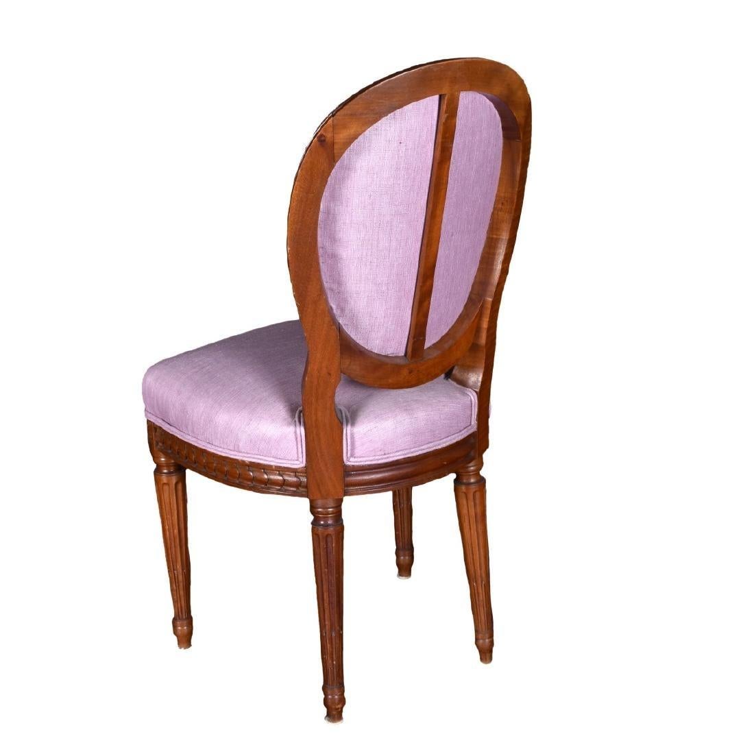 Directoire-style dining chairs illustrate the minimally adorned style that became favorable after the French Revolution. Neoclassical carved wood dining chair set of 4 circa 19th Century France. Beautiful set of four carved wood dining chairs.