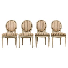 Ensemble de quatre chaises de salle à manger peintes de style Louis XVI
