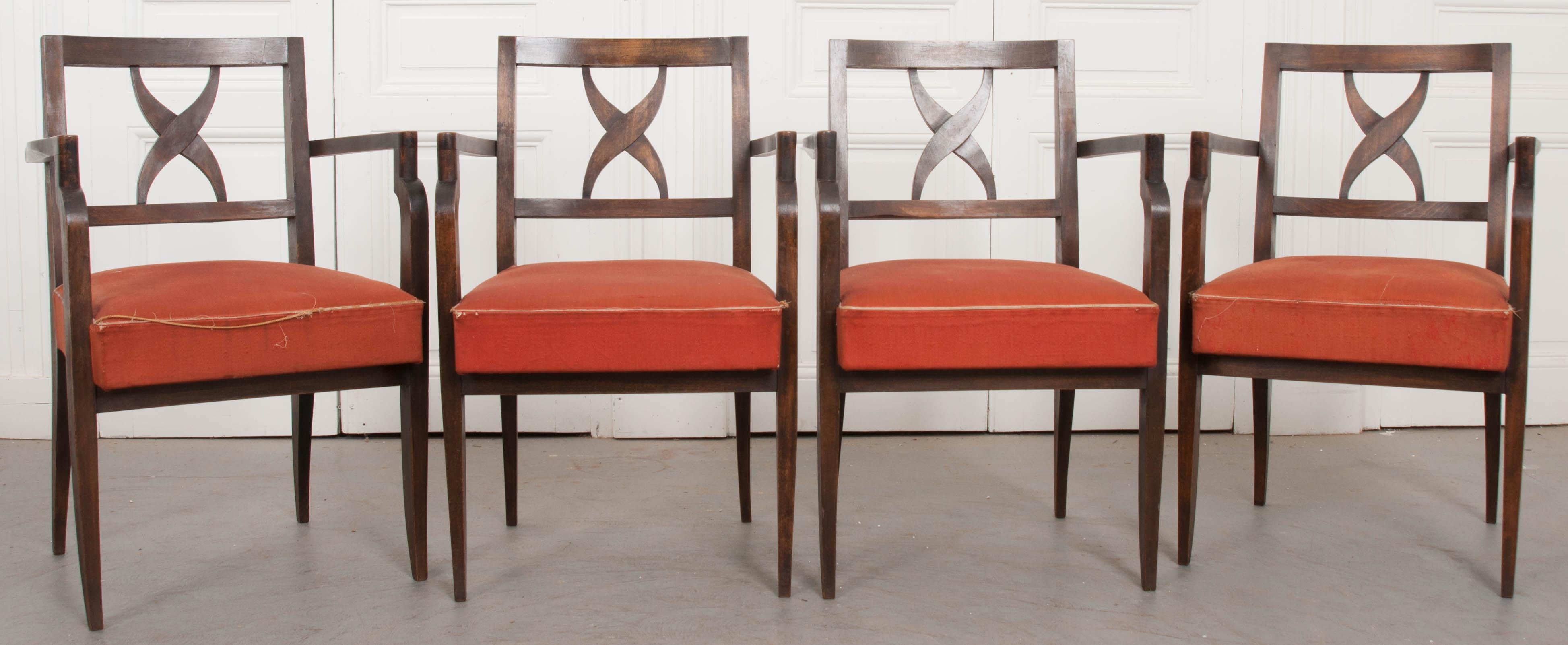 Ein eleganter Satz von vier französischen Sesseln aus Nussbaumholz aus der Mitte des Jahrhunderts mit gepolsterten Sitzen. Die Stühle haben ein Design, das sowohl gerade Linien und rechte Winkel mit Kurven und formvollendeten Formen verbindet. Die