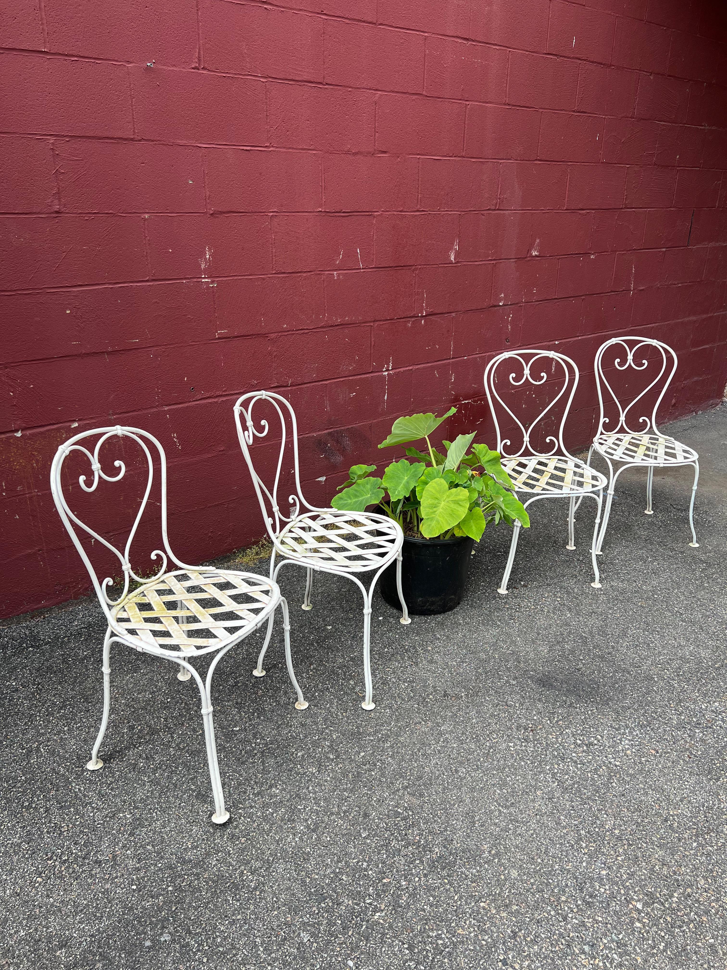 This set of four beautiful French garden chairs will be an elegant addition to any outdoor seating area or garden. The chairs are constructed from white-painted iron, and feature decorative scroll detail in the backs along with intricate