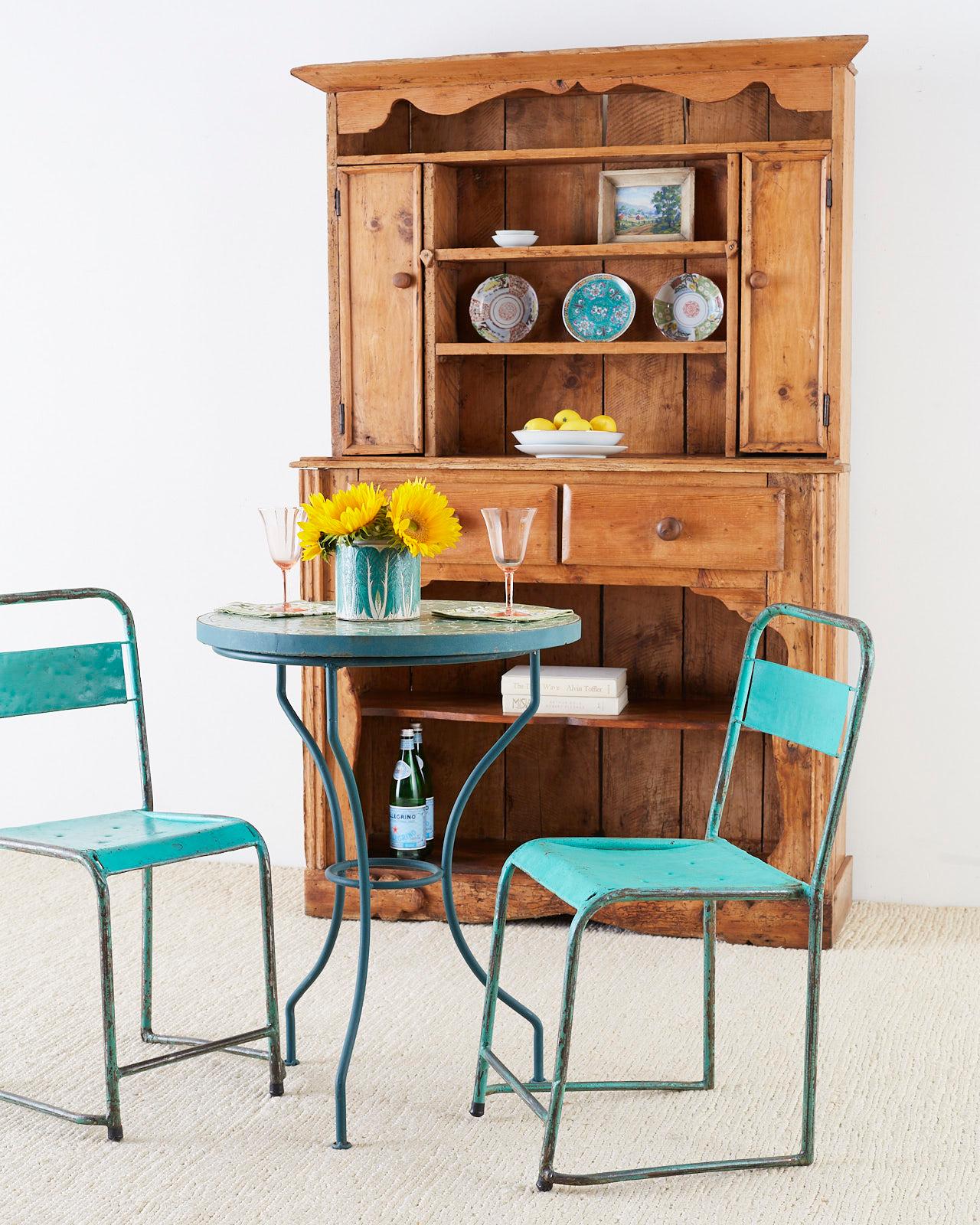 Charming set of four early 20th century French stacking garden chairs featuring a rustic green painted patina. Probably school house chairs originally or outdoor bistro chairs. They now have a distressed finish with tons of character. Lightweight