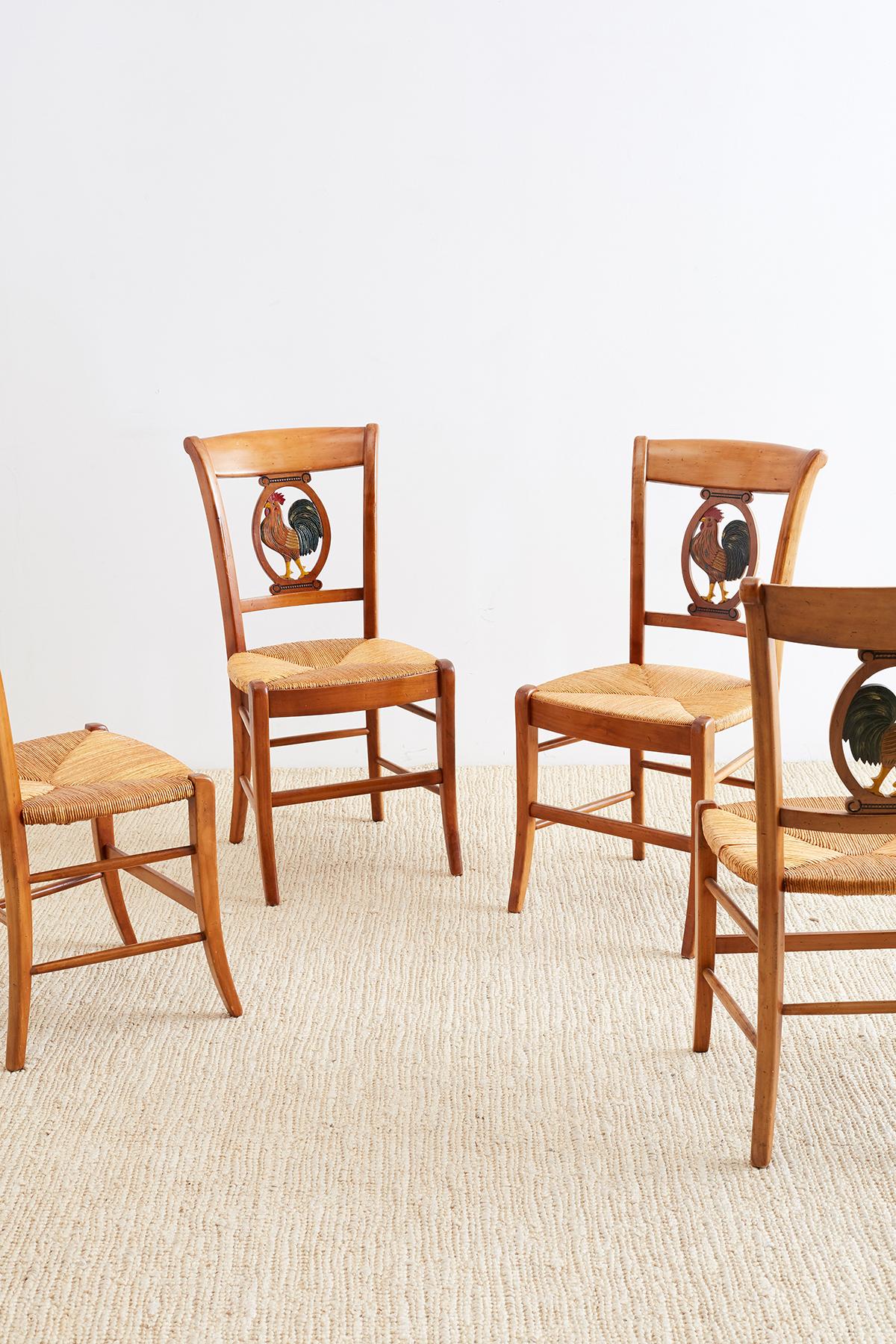 French country set of four rush seat dining chairs featuring a carved backsplat with a painted rooster. handmade in the French Provincial style from fruitwood each chair is signed by artisan on bottom. Unique and charming with excellent joinery and