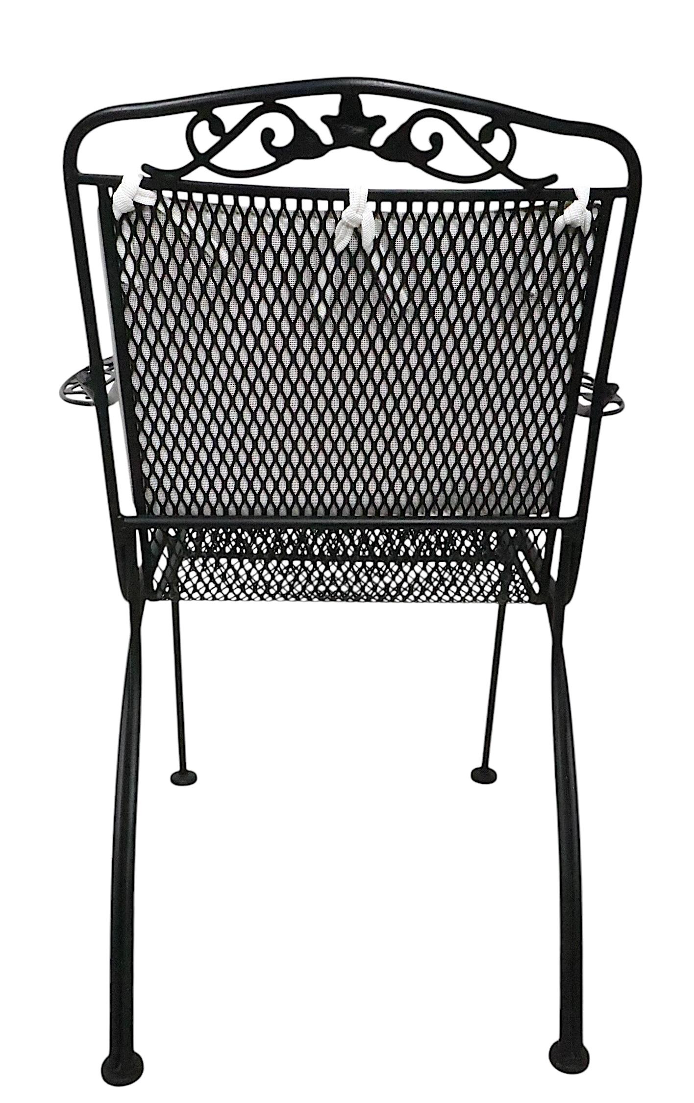 Slick set of four wrought iron and metal mesh dining chairs, with original, removable seat and back cushions. The four arm chairs are all in excellent, clean, ready to use condition, free of damage or repairs. 
 Offered and priced as a set of four,