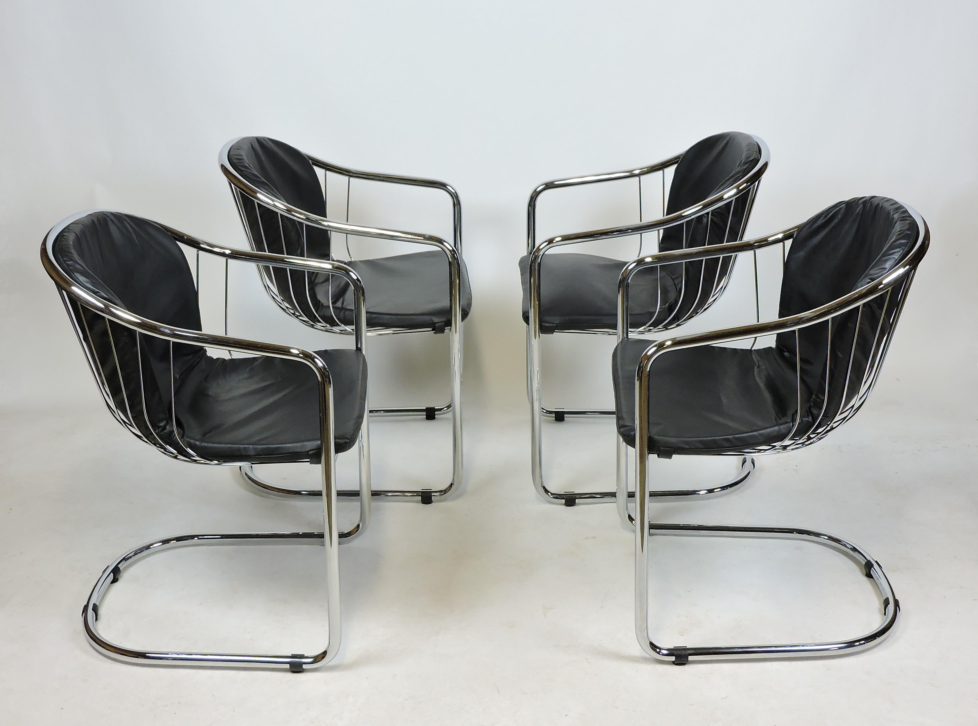 Sleek and sexy set of four chrome cantilevered chairs designed by Gastone Rinaldi. These chairs have tubular and wire chromed metal frames with high quality black leather seat cushions.
 