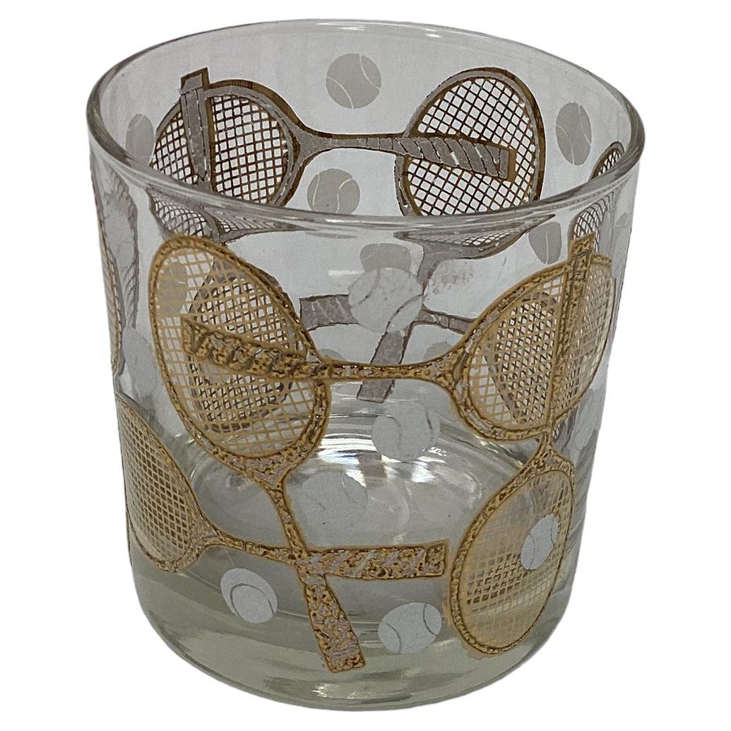 Set of Four Georges Briard Tennis Rock Glasses. Raised gold applied decoration of crossed tennis rackets with white floating tennis balls. There are two sets of four available. Both sets are listed.