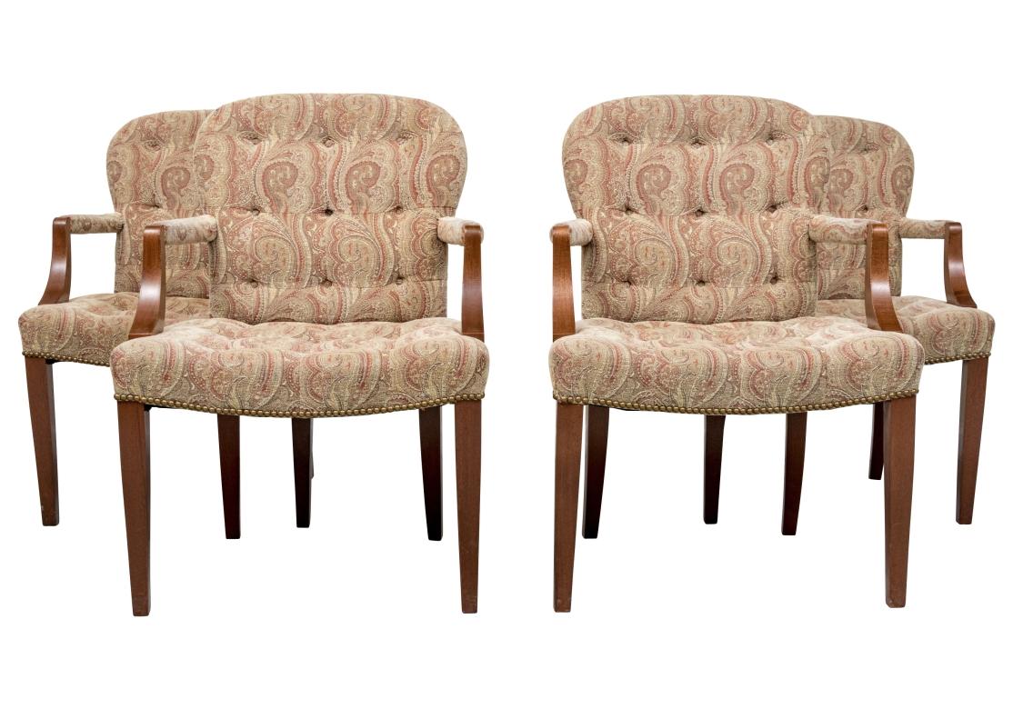 Set of four Georgian style armchairs in soft textured paisley print with sloop arm support, fully covered manchettes, button tufted seat and backrest, resting upon straight tapering front legs and saber back legs. The arm chairs with rope trim to
