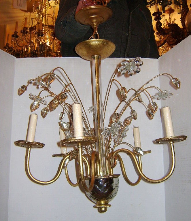 Un ensemble de 4 lustres français à 5 lumières en métal doré datant des années 1940 avec une coupe en verre au mercure et des feuilles et fleurs en verre moulé. Vendu à l'unité.

Mesures :
Hauteur 25 ? chute min
Diamètre 21 ?