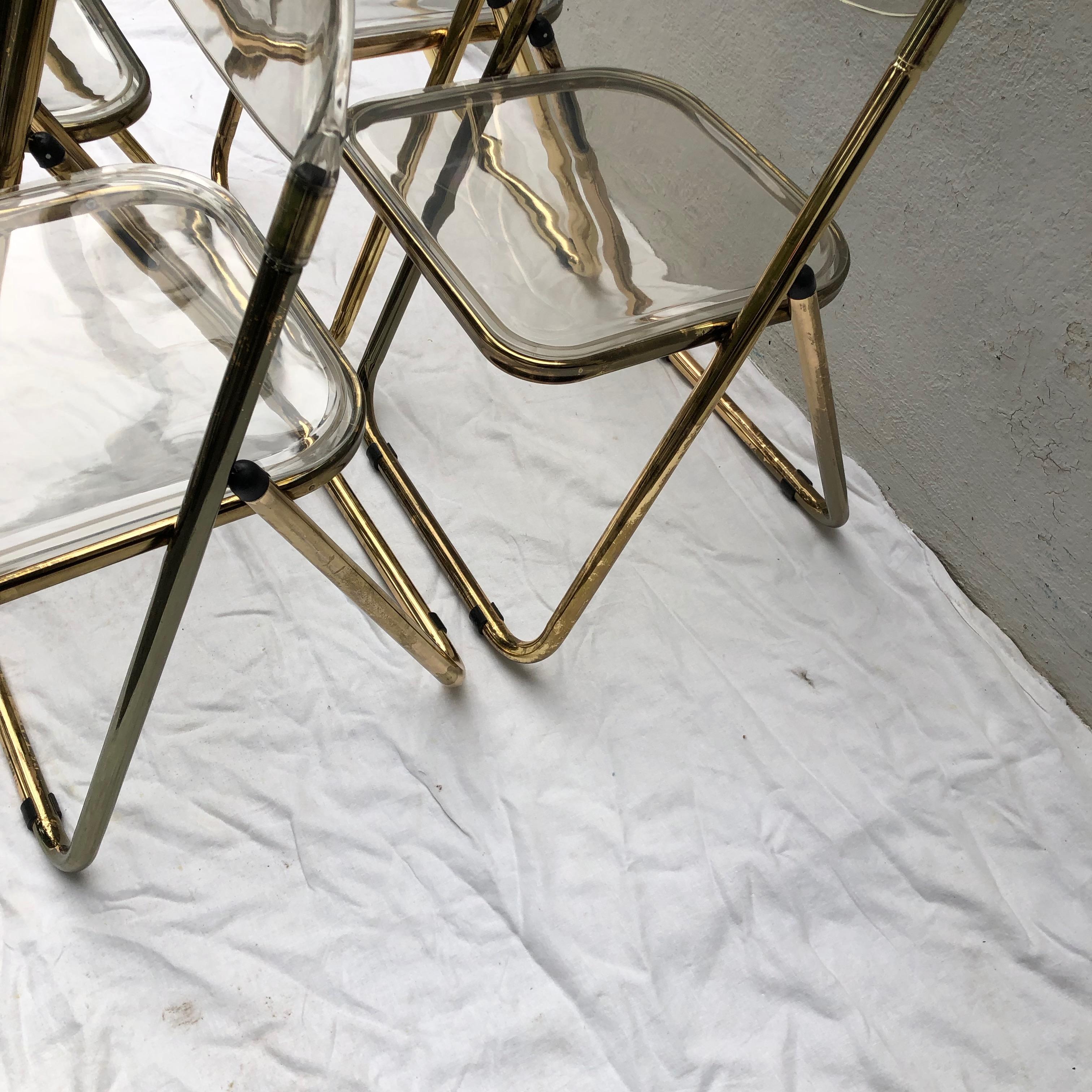 Metal Set of Four Gold Plia Folding Lucite Chairs in the Style of Giancarlo Piretti For Sale