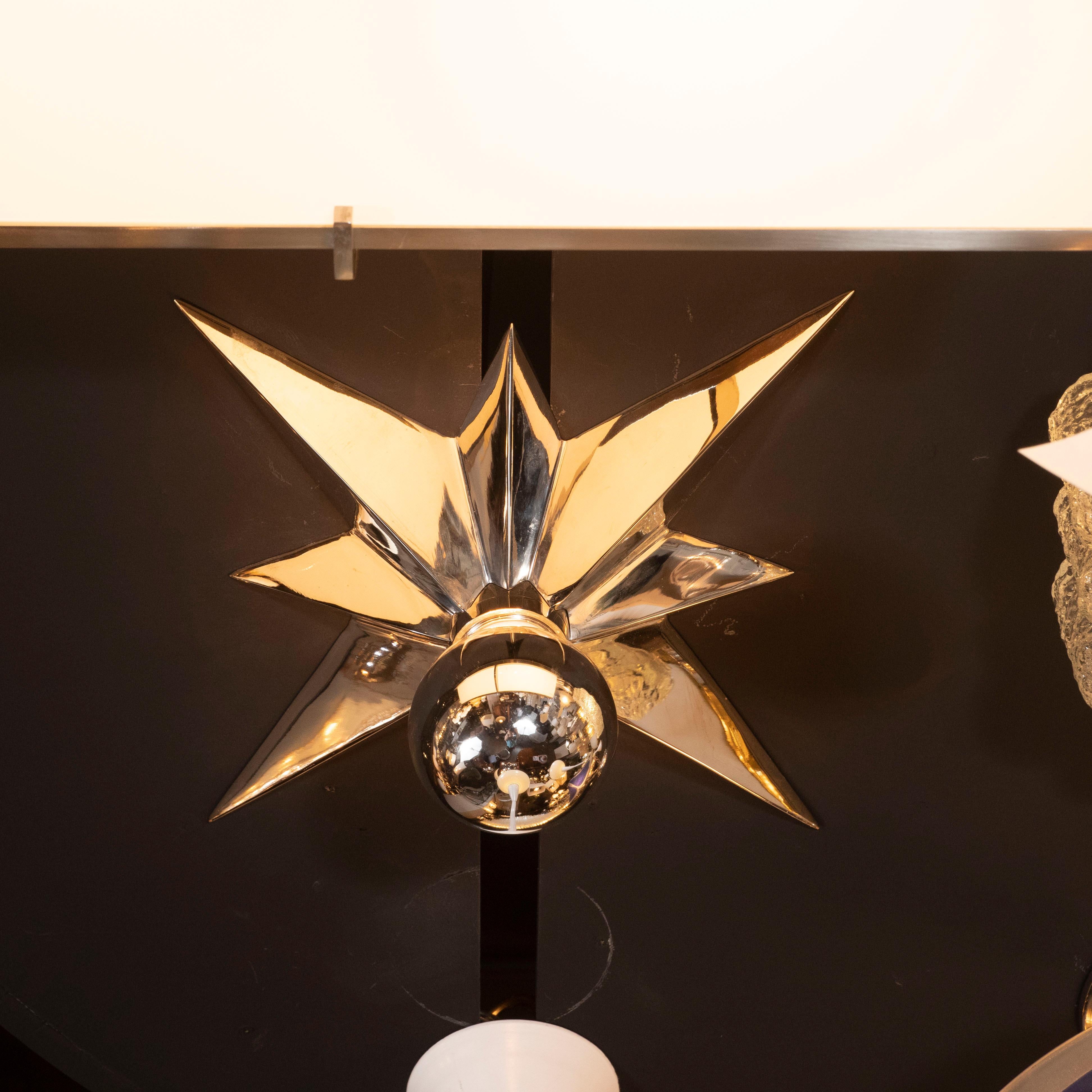 This graphic and refined set of three flush mounts were realized in the United States, circa 1980. Each flush mount features an eight pointed star executed in lustrous polished nickel that tapers towards each end. A mercury bulb lies in the center