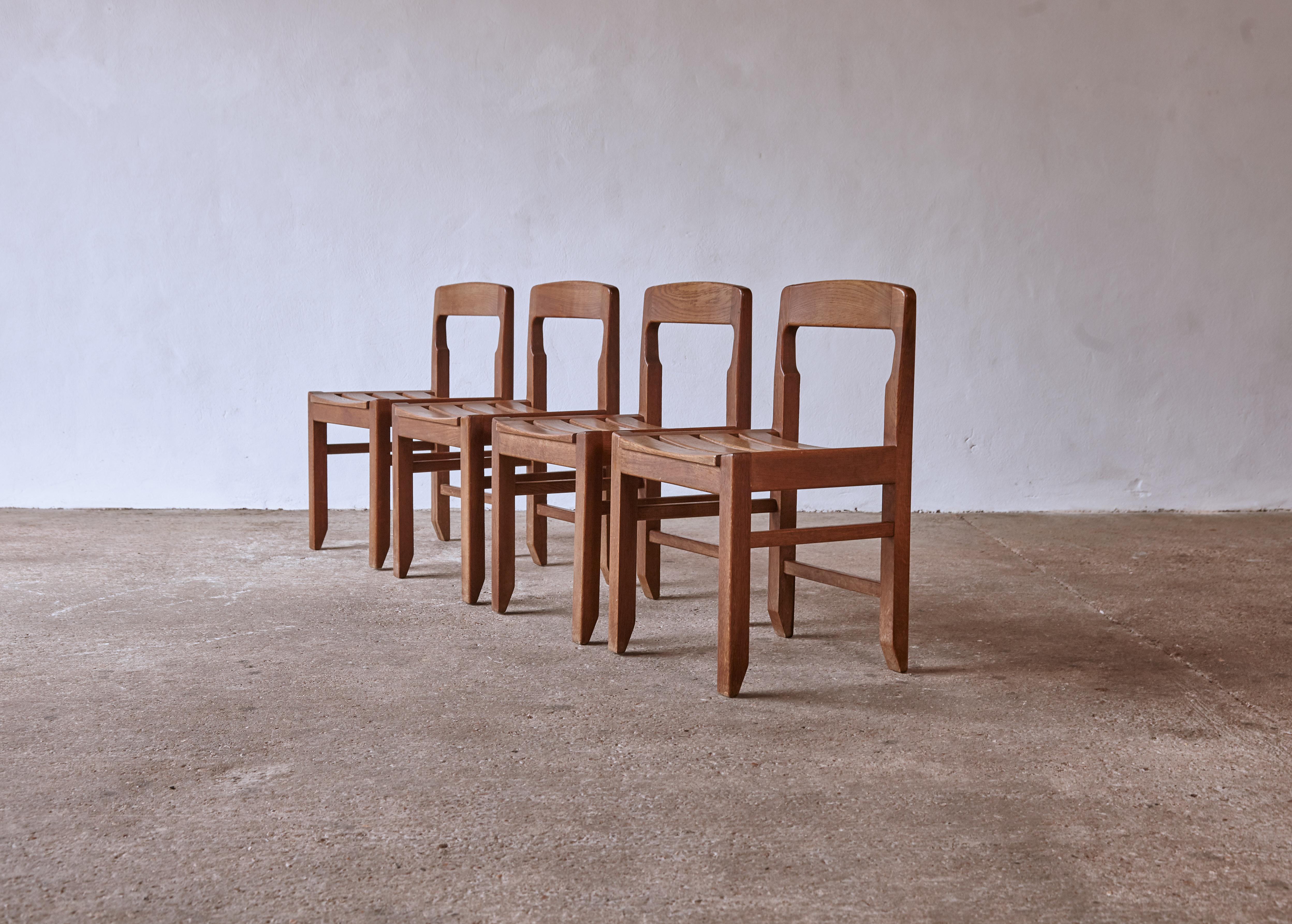 Un ensemble de quatre superbes chaises de salle à manger Guillerme et Chambron en chêne massif, fabriquées en France dans les années 1960. Structurellement en bon état avec un ton et une patine d'ensemble agréables et uniformes. Très beaux exemples