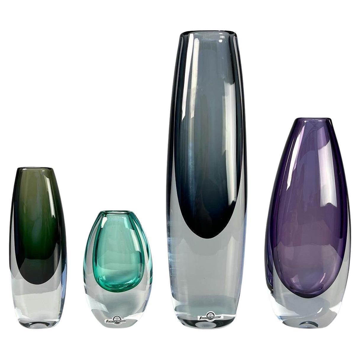 Gunnar Nylund vases in colored and clear crystal for Strömbergshyttan, Sweden 1960s. 

Left to right:

• Dark green, model B936, signed, very good condition, h: 19 cm

• Large gray-blue, model B936, signed, h: 35 cm

• Small clear turquoise,