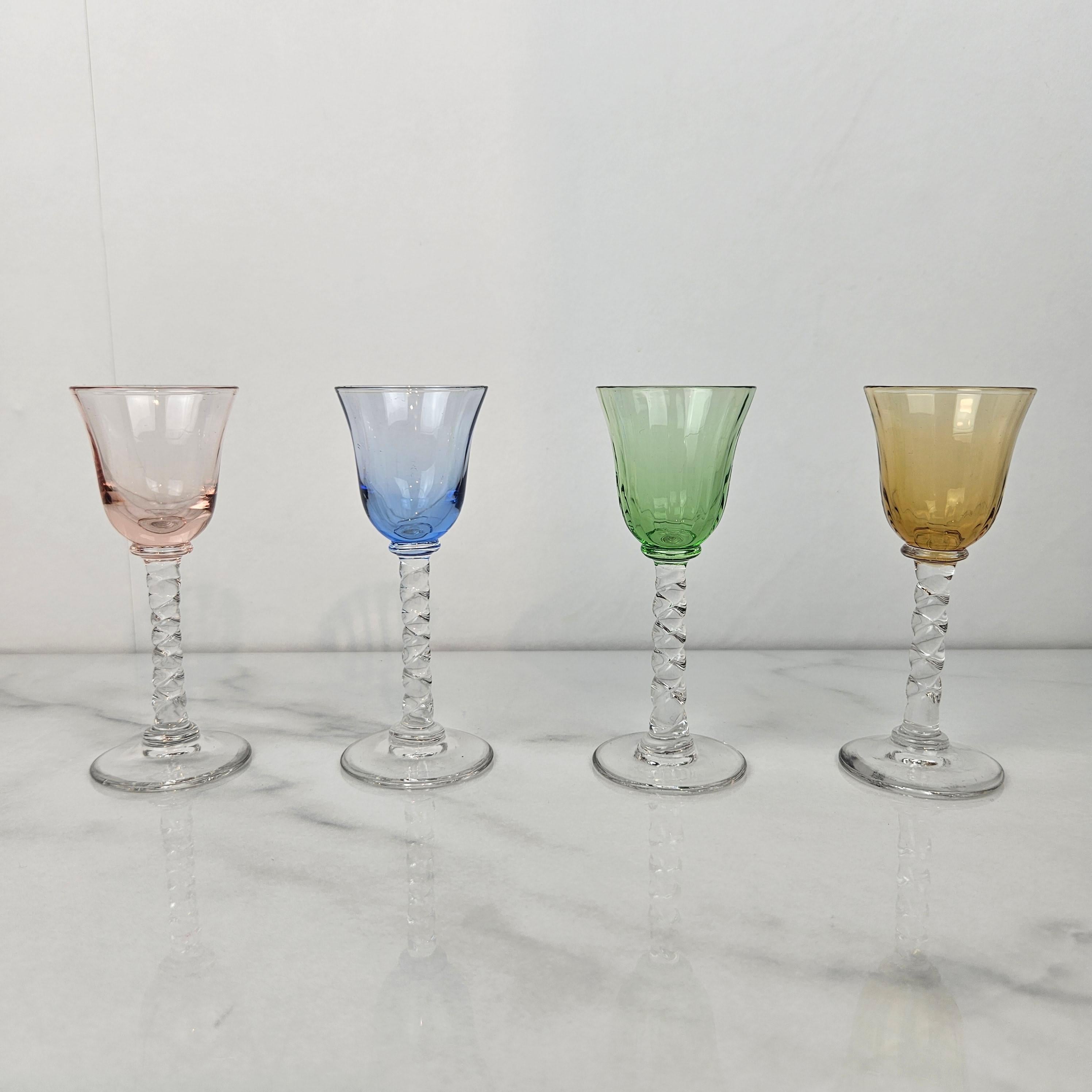 An exquisite set of four hand-blown cordial glasses dating from around 1930. Each glass features a beautifully twisted stem and a lightly ribbed bowl in soft, translucent tones — smoke grey, green, blush pink, sky blue, pale aqua, and amber.

The