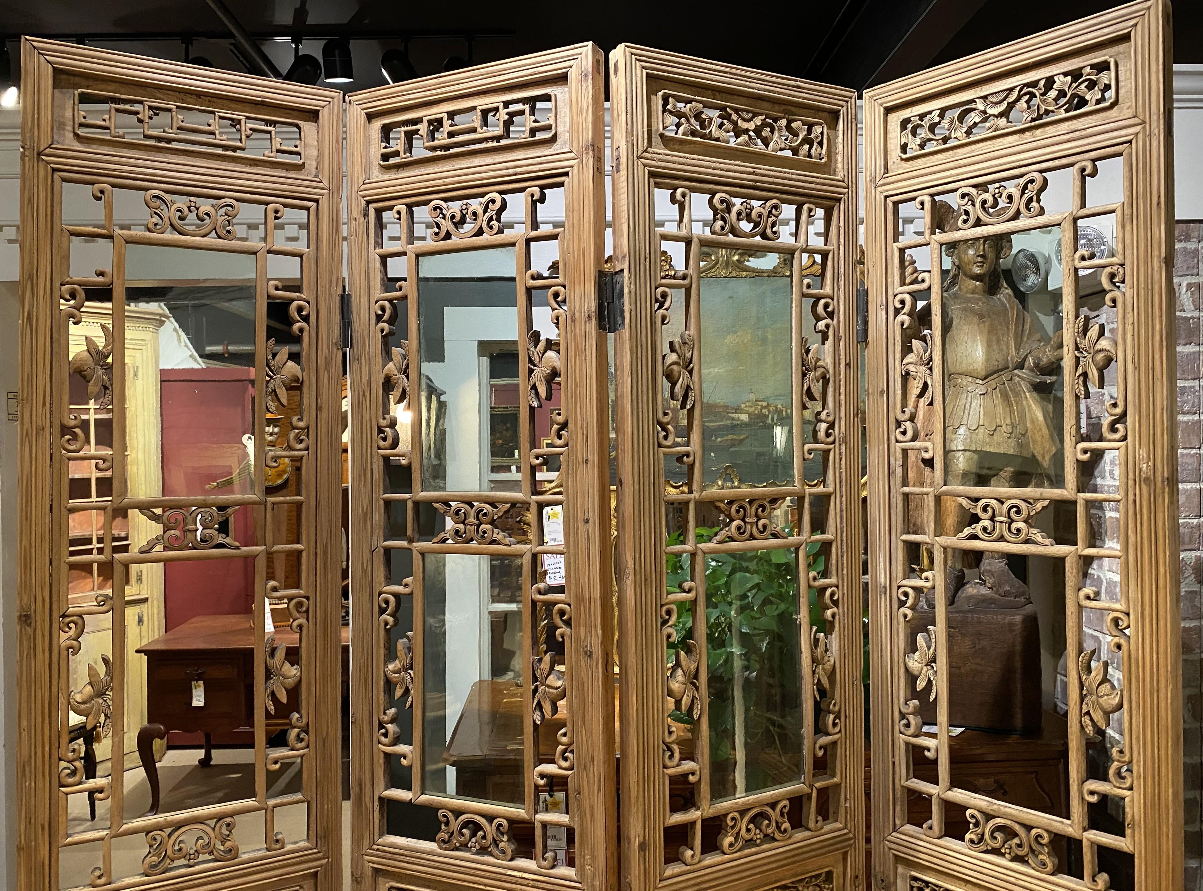 Fino conjunto de cuatro paneles abiertos de madera dura china tallada a mano con cristales transparentes, varios paneles de escenas folclóricas figuradas talladas, acentuadas con animales y decoración folclórica y de volutas alrededor de los paneles