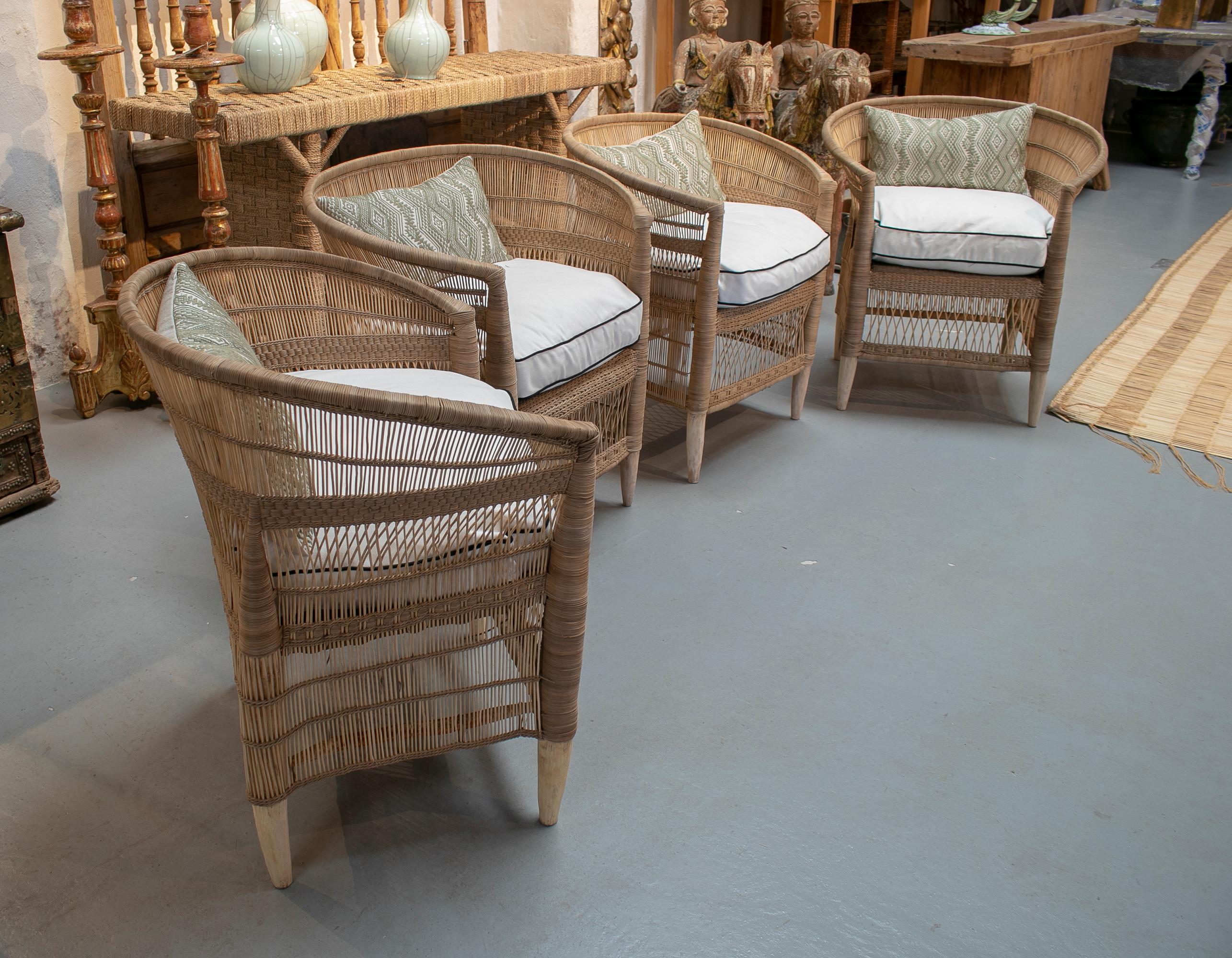 Set of four hand woven rattan wooden upholstered armchairs.