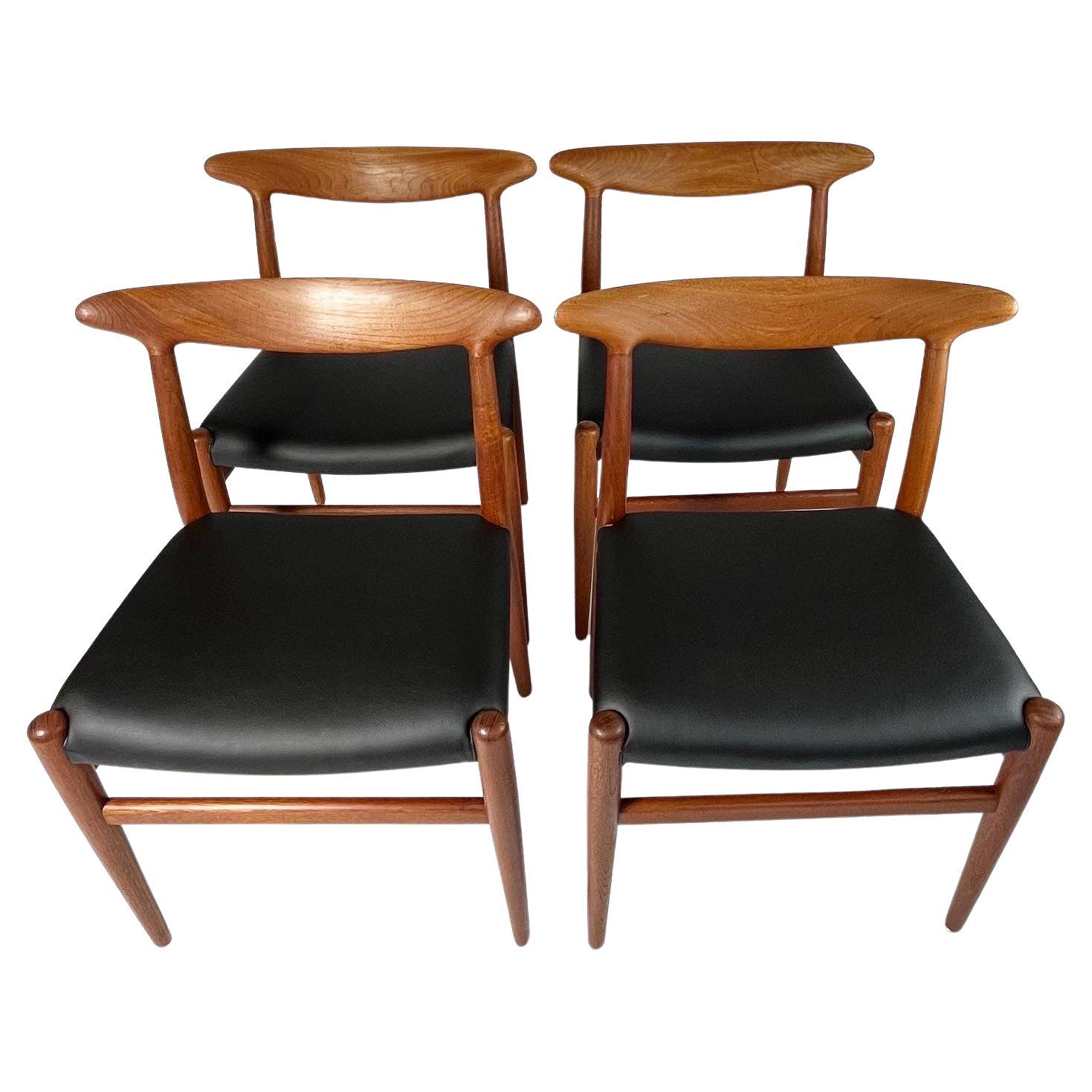Set of four Hans J. Wegner dining chairs, model W2, designed in 1953 for C.M. Madsens Fabriker in Denmark.

Solid teak frames, new upholstered with award winning black cacti leather by Desserto, a beautiful plant-based and more sustainable