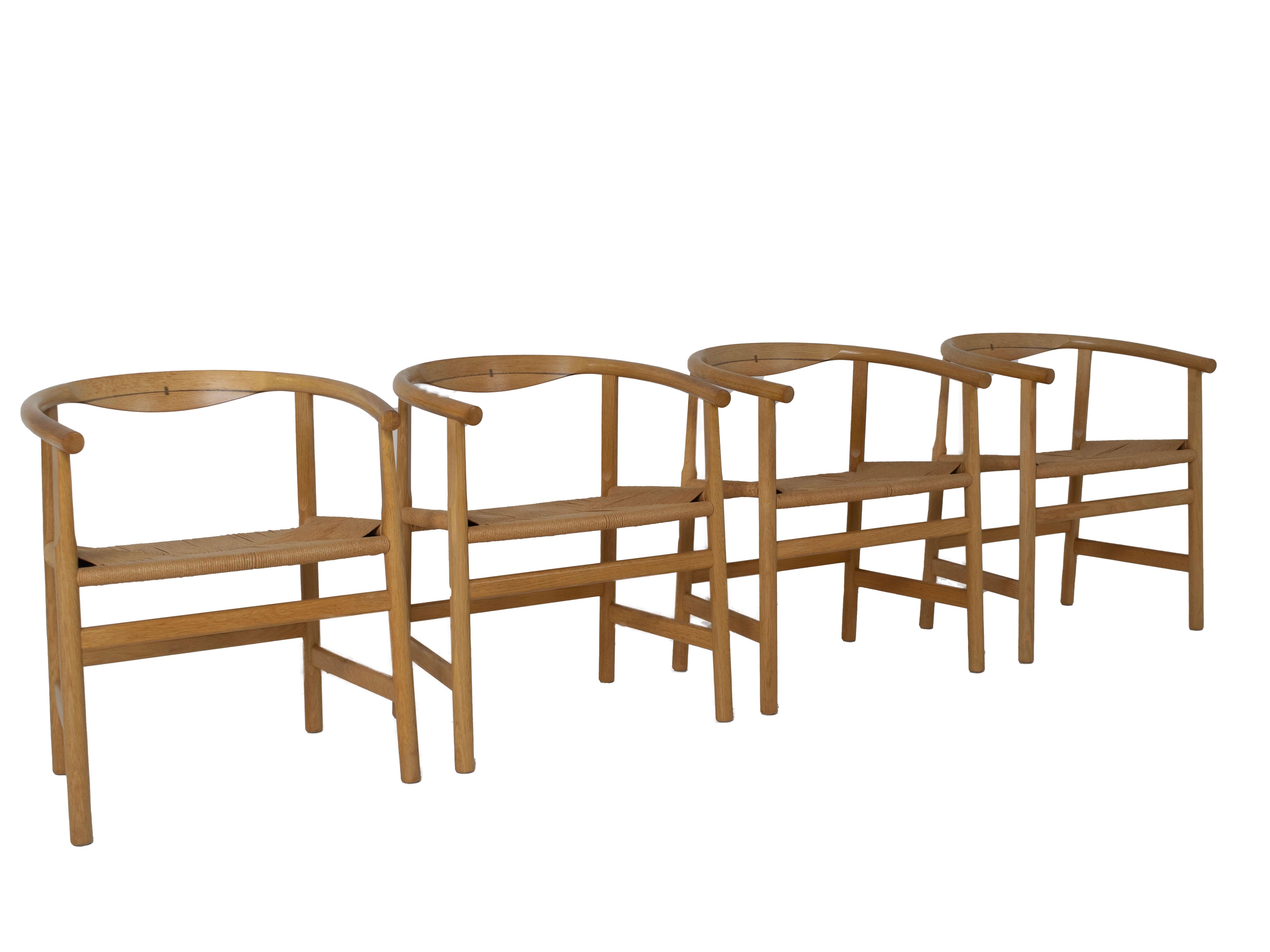 Amazing set of four armchairs designed by Hans Wegner and manufactured by PP Møbler, Denmark. These chairs are made of solid oak with wenge inlay. The seat is made of papercord. The design is timeless and very on-trend, for example in combination