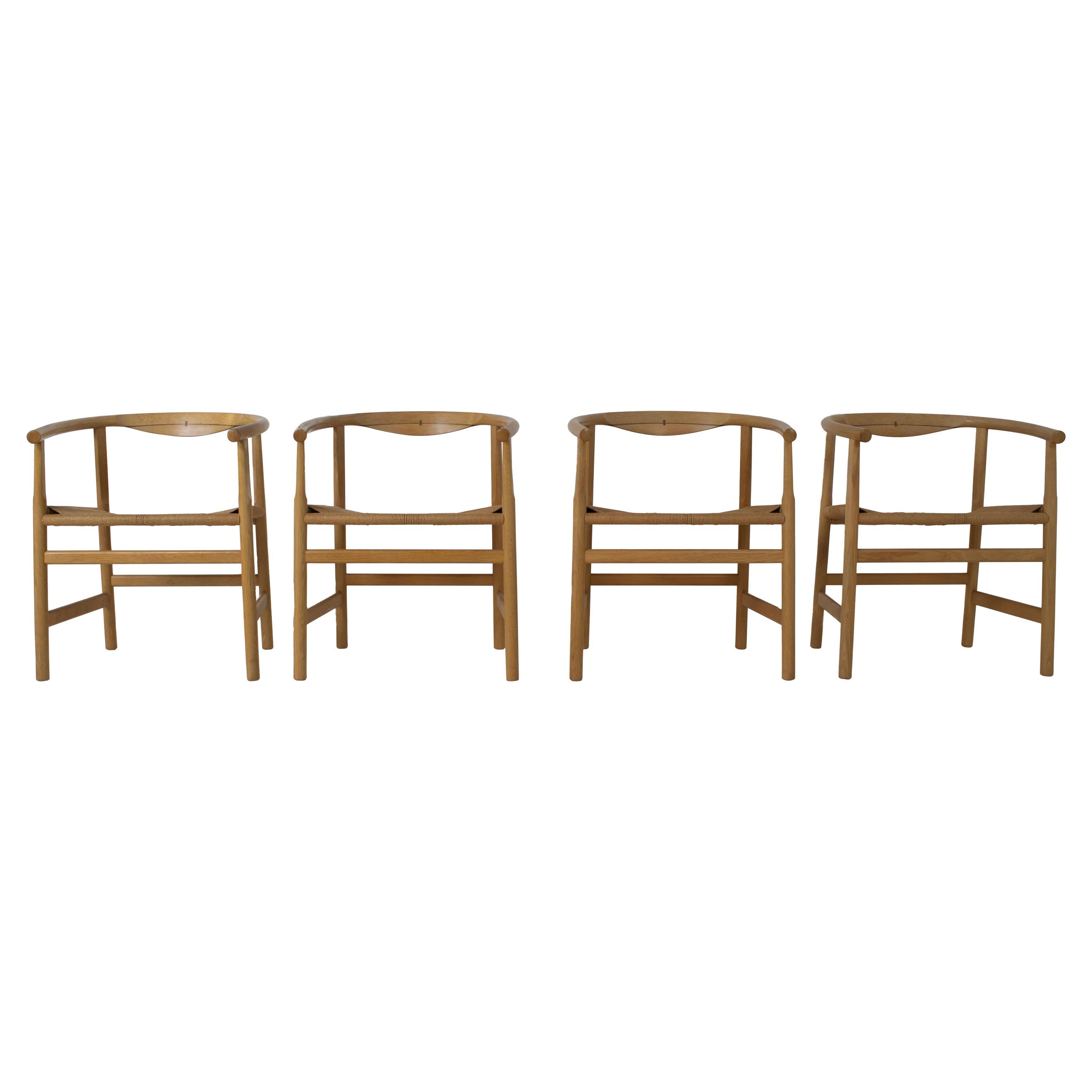 Amazing set of four armchairs designed by Hans Wegner and manufactured by PP Møbler, Denmark. These chairs are made of solid oak with wenge inlay. The seat is made of papercord. The design is timeless and very on-trend, for example in combination