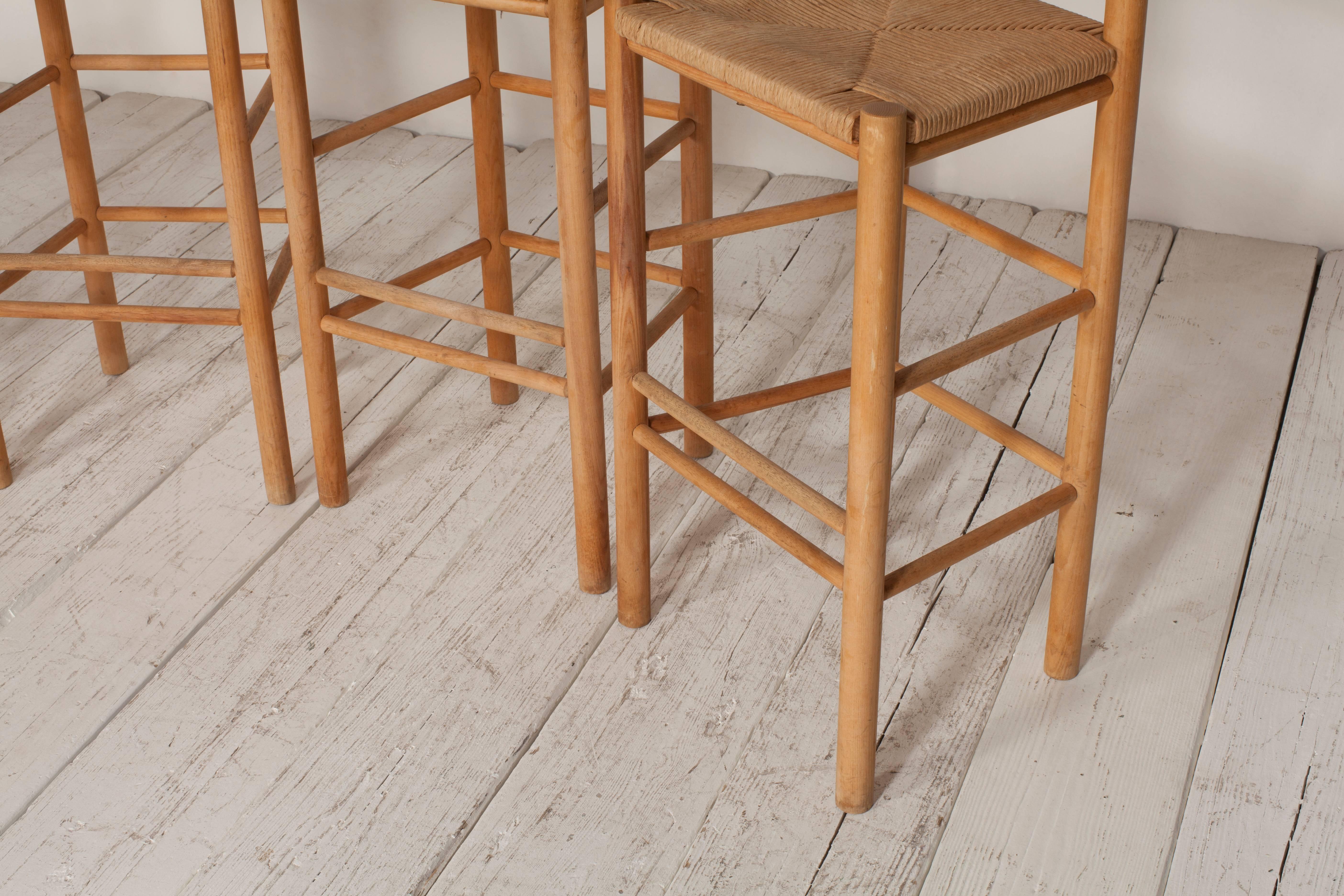 Set of four Hans Wegner style natural oak bar stools with rush seat.